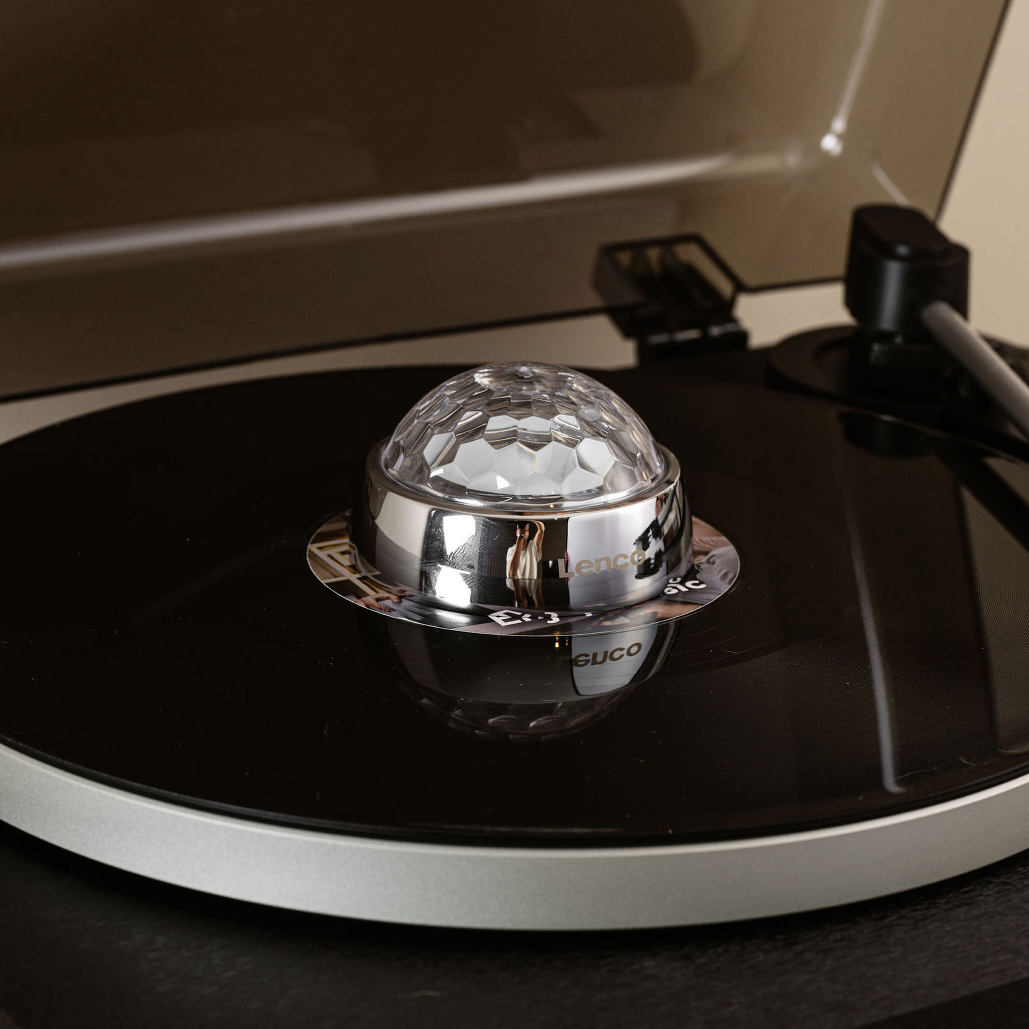 Een platenspeler met een discobal op de plaat.