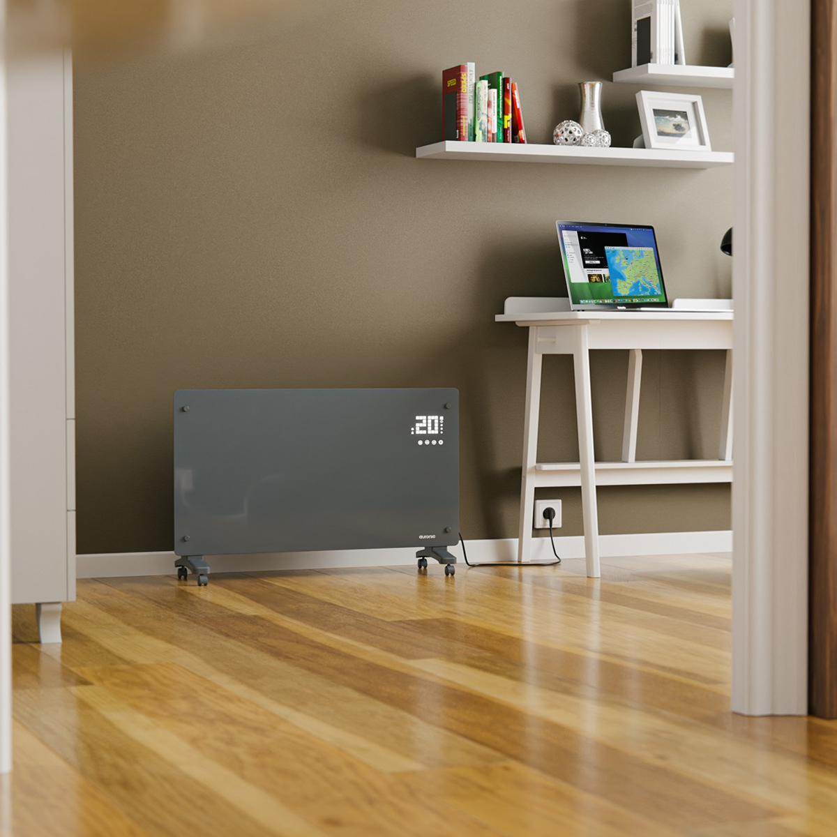 A gray heater with a display. It is placed on a wooden floor. A laptop and a shelf are visible in the background.