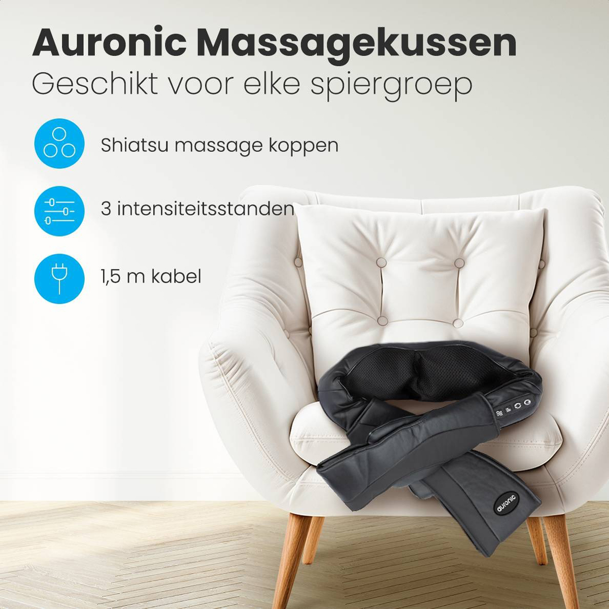 Black massage pillow on a white armchair. Labels include Shiatsu massage heads, 3 intensity settings, and a cable.