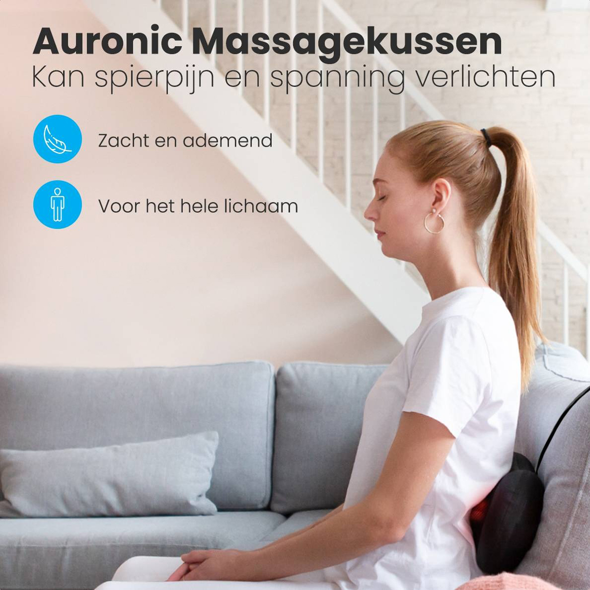 Frau sitzt auf einem Sofa mit einem Massagekissen auf dem Rücken.