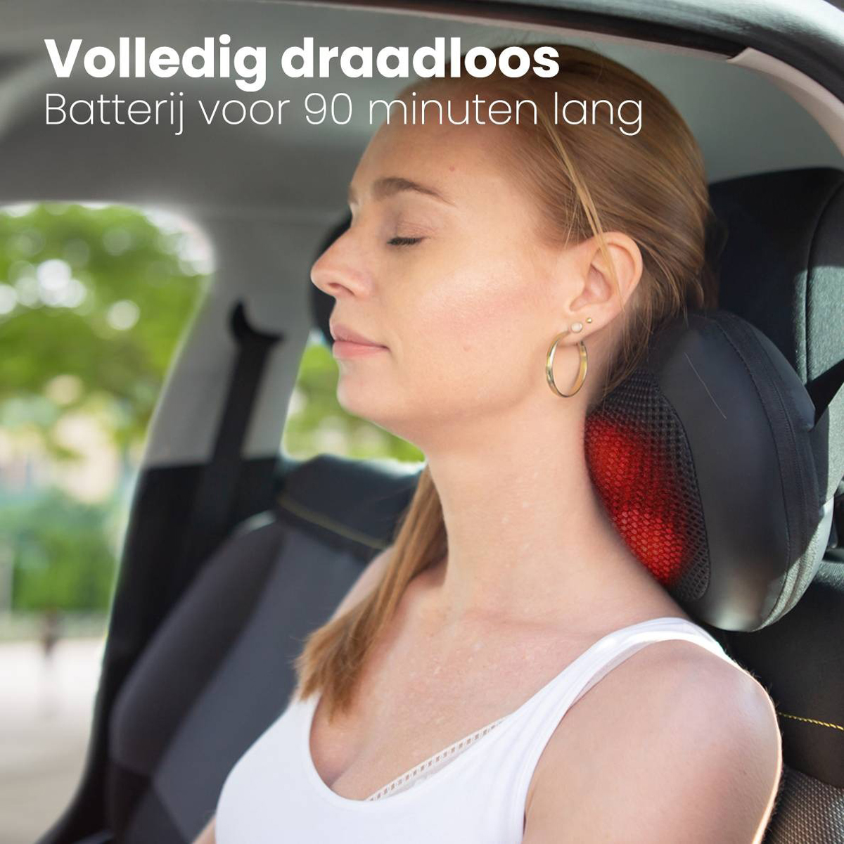 Frau im Auto mit Massagekissen auf dem Nacken, Augen geschlossen. Rotes Licht vom Kissen sichtbar.