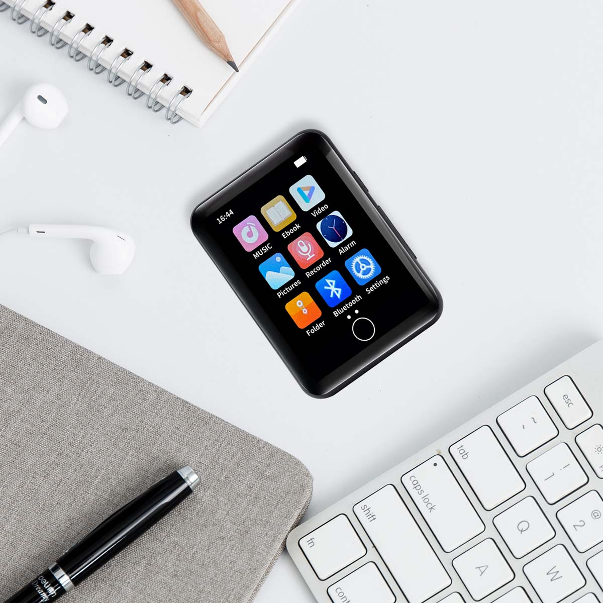 Czarny przenośny odtwarzacz muzyki z ikonami na ekranie i akcesoriami wokół.