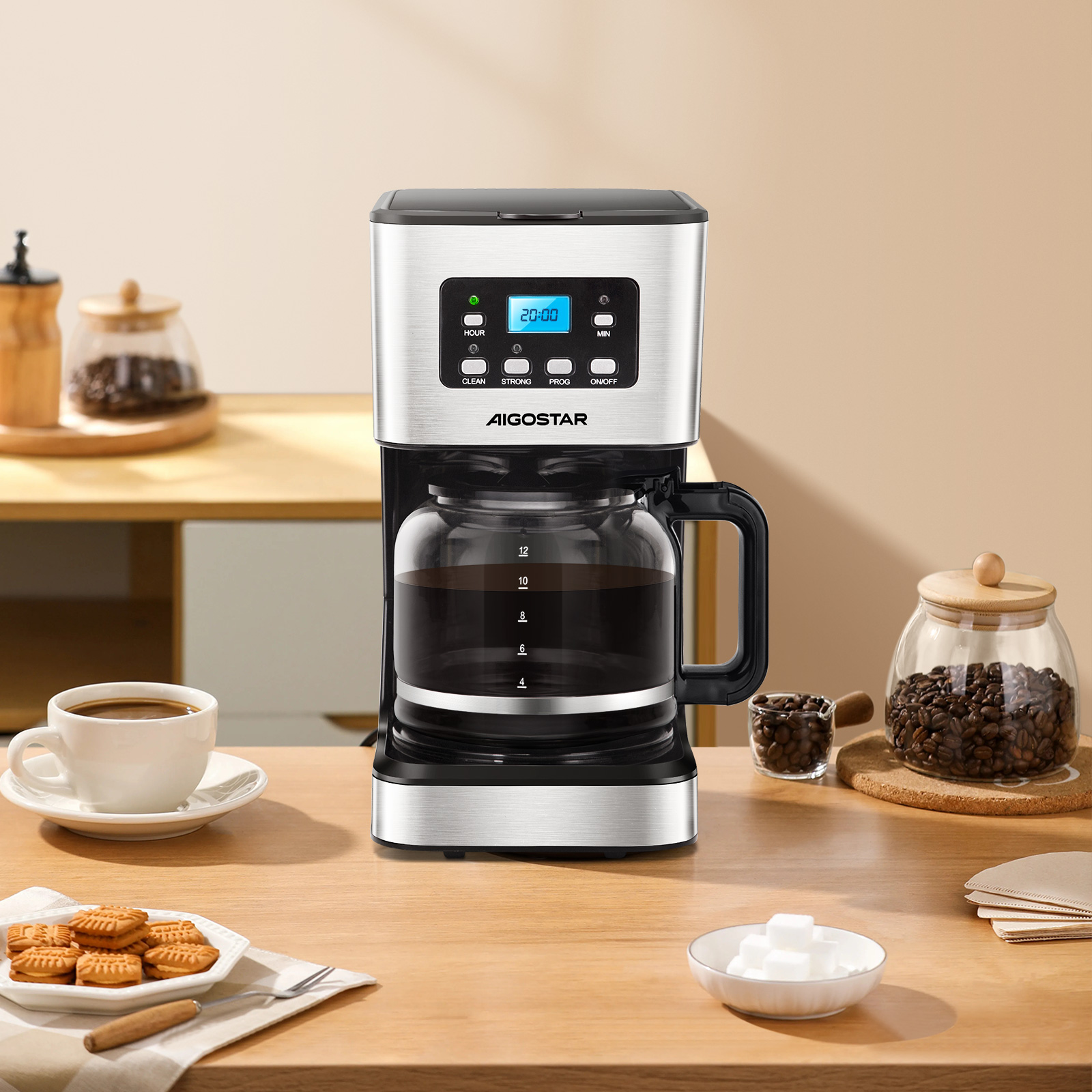 Cafetera con jarra de vidrio, café, azúcar y galletas en una mesa de madera.