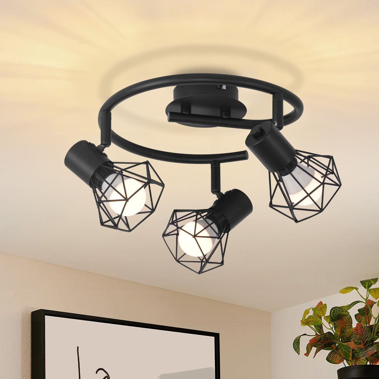 Luz de techo con tres focos negros en forma de jaula sobre una pista circular negra.
