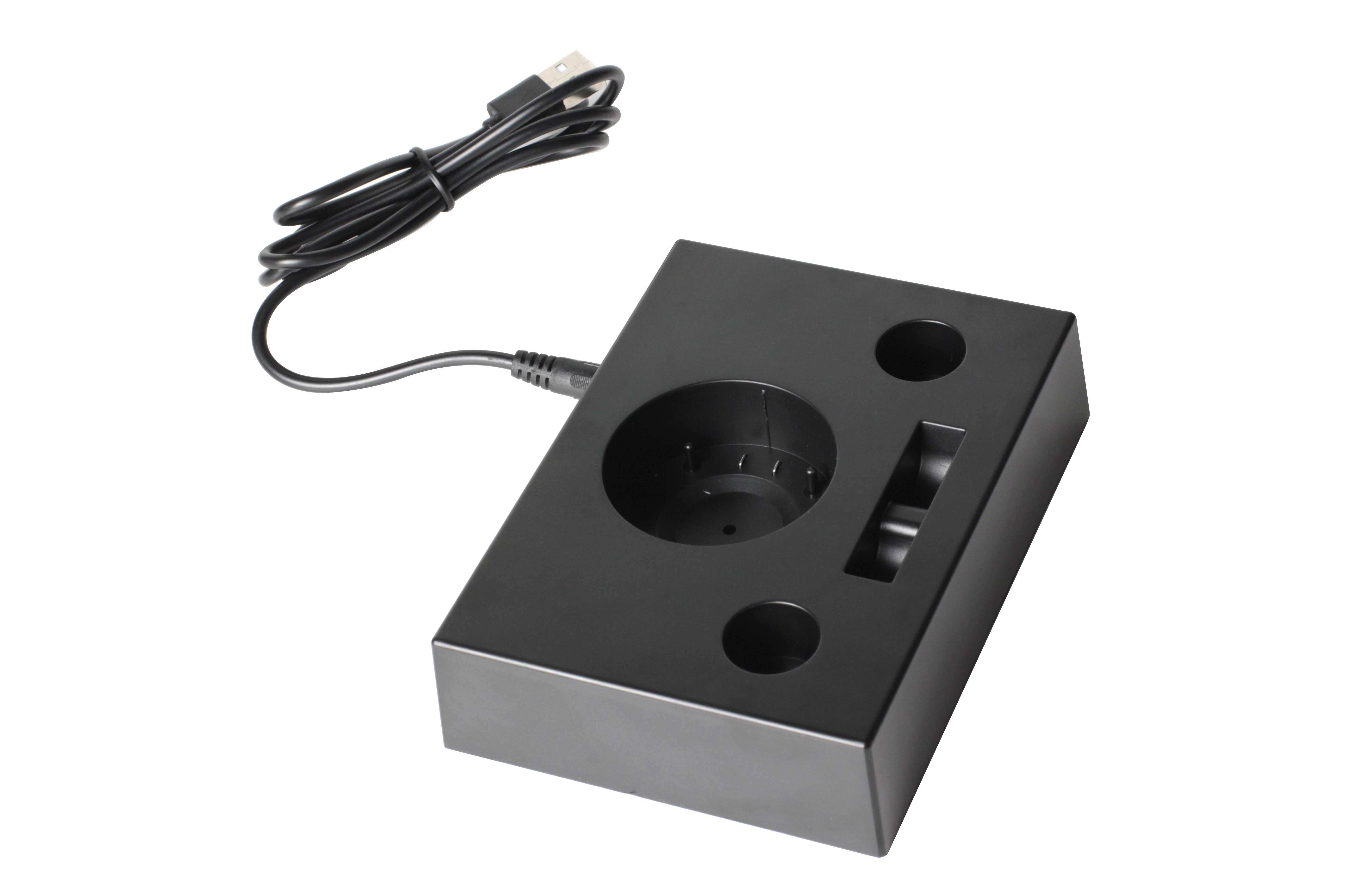 Eine schwarze Ladestation mit USB-Kabel. Sie hat ein rundes und ein rechteckiges Loch.