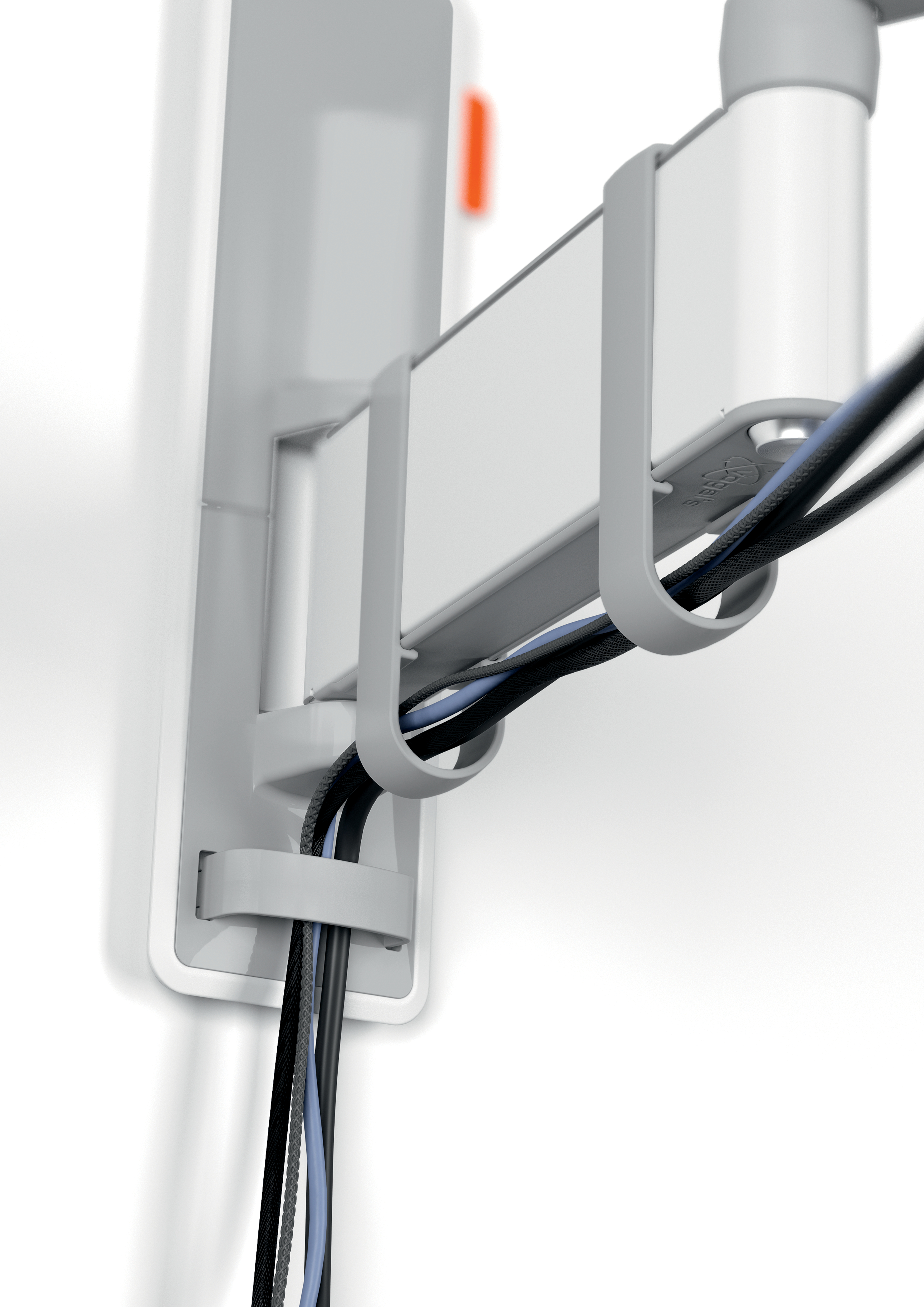 Zbliżenie na system zarządzania kablami z kablami biegnącymi wzdłuż białej ściany.