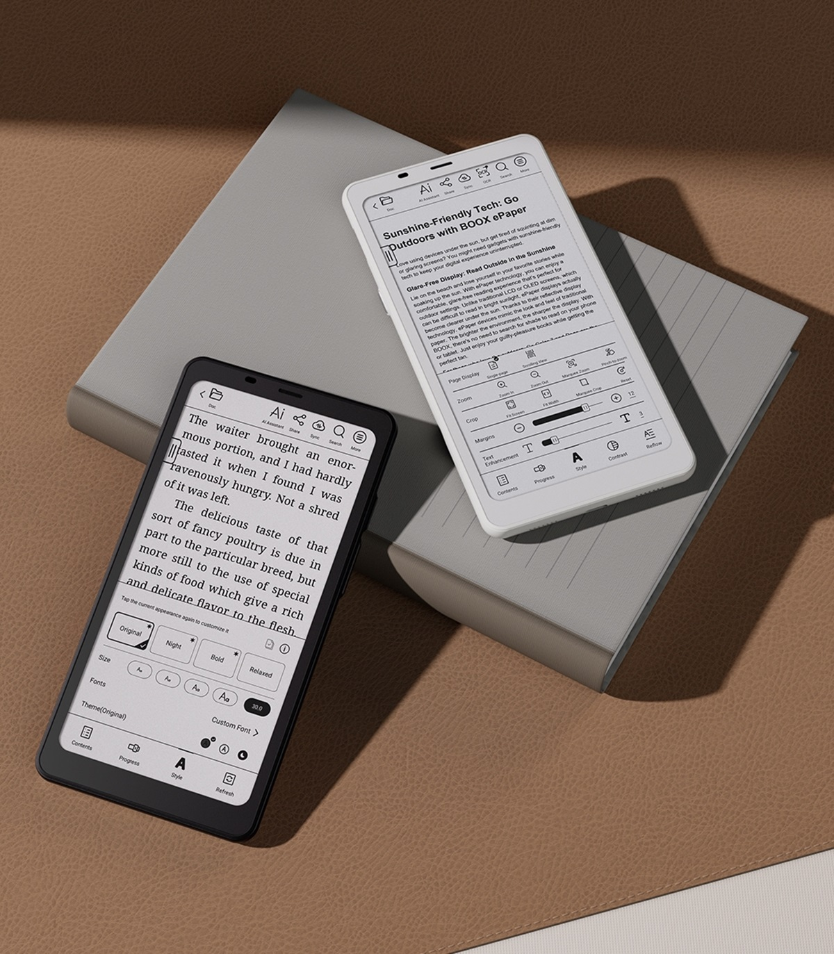 Dwa czytniki e-booków, jeden czarny, jeden biały, na szarej powierzchni. Oba wyświetlają tekst.
