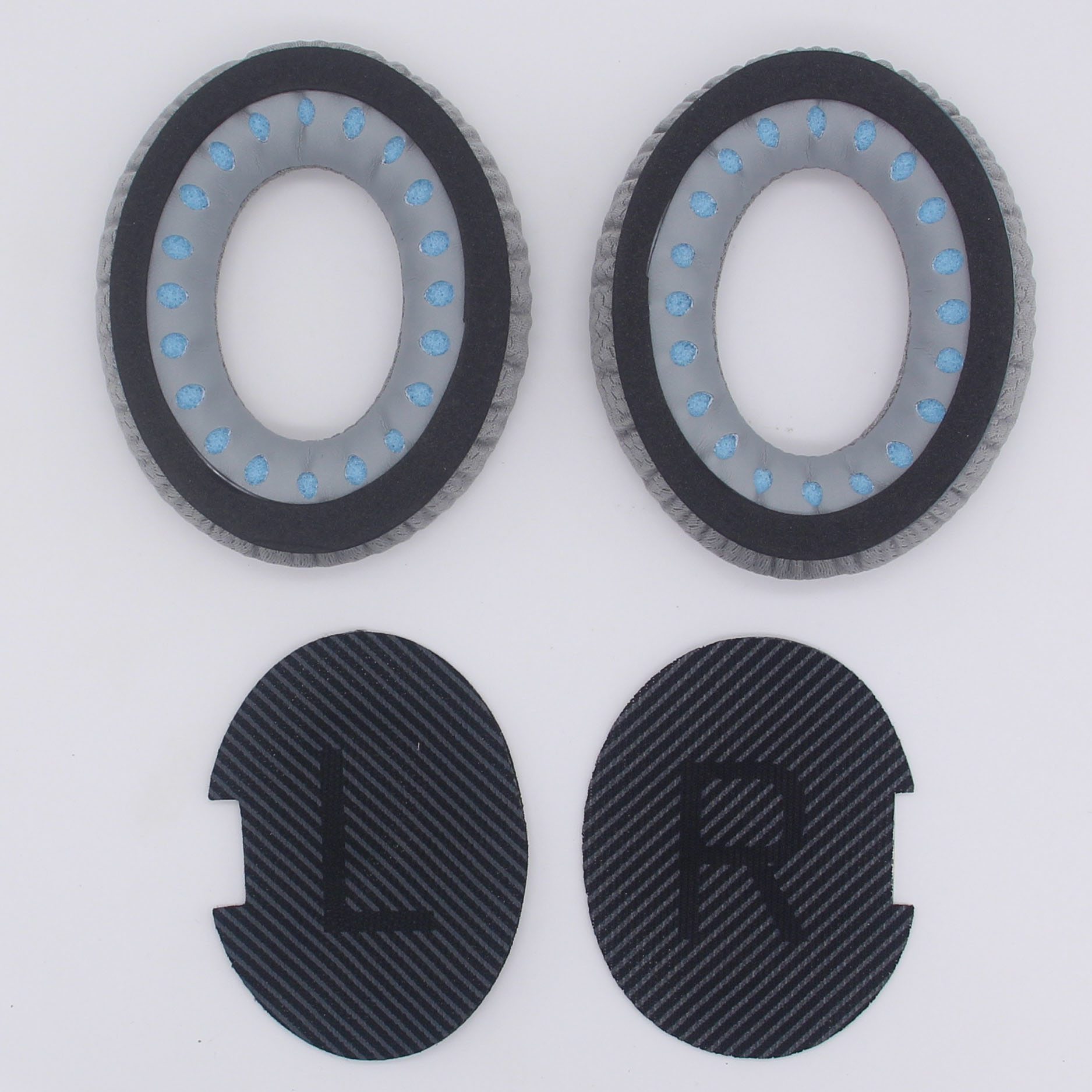 Due cuscinetti auricolari grigi per cuffie e due cuscinetti neri con etichette 'L' e 'R'.