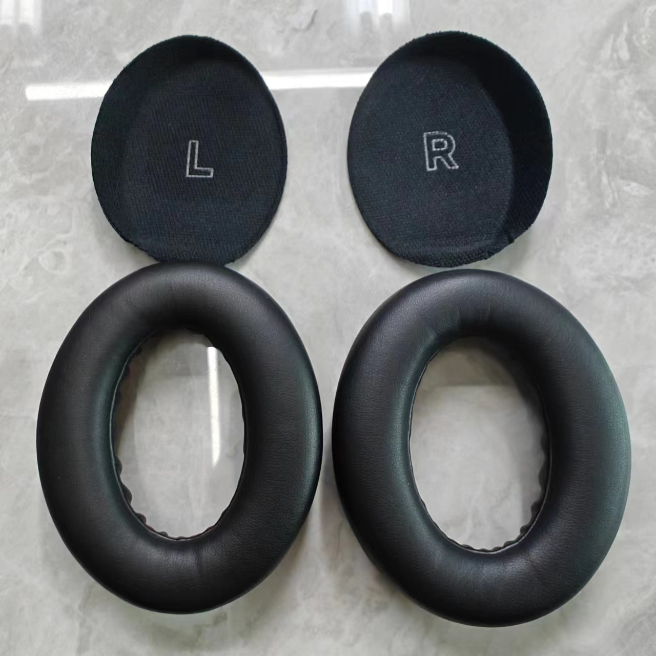 Twee zwarte oorkussens en twee zwarte oorschelpen met L- en R-labels.