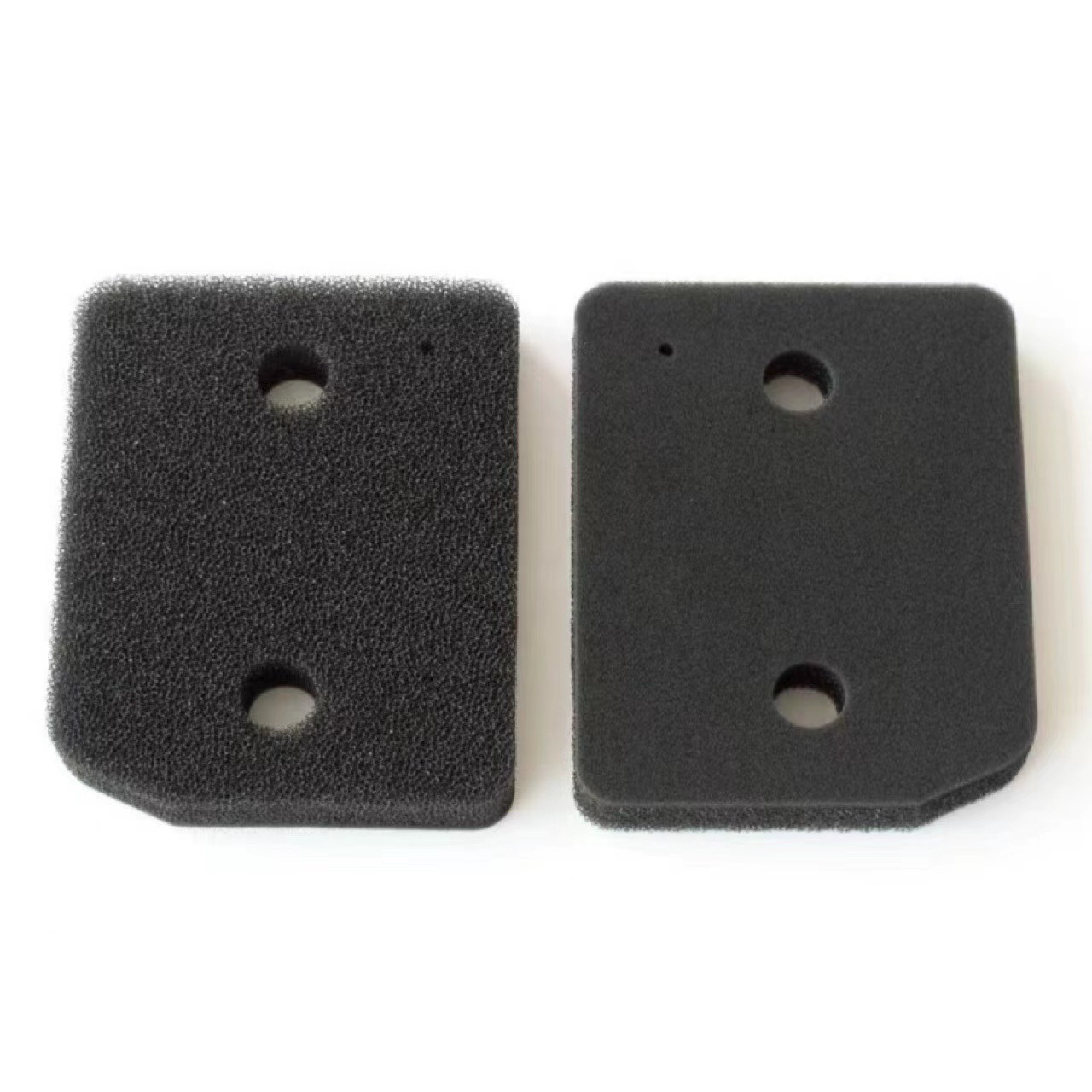 Dwa czarne filtry piankowe z otworami, do silnika. Jeden jest nowy, drugi używany.