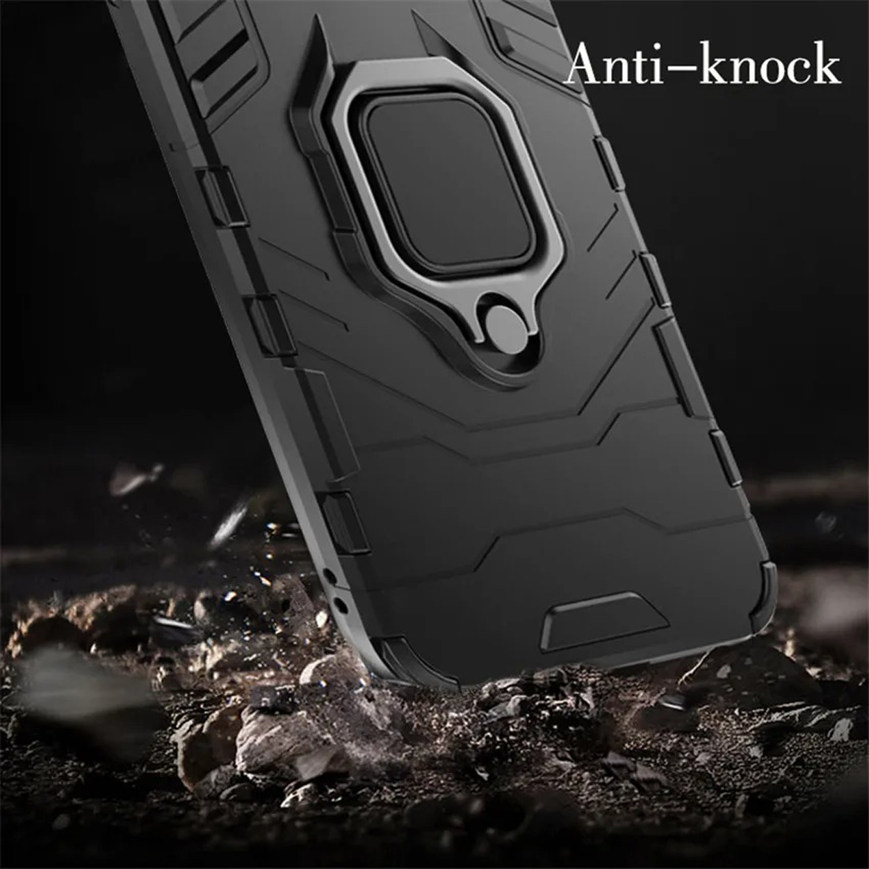 Een zwarte telefoonhoes wordt getoond met een metalen ring. De hoes ligt op een oppervlak met puin.