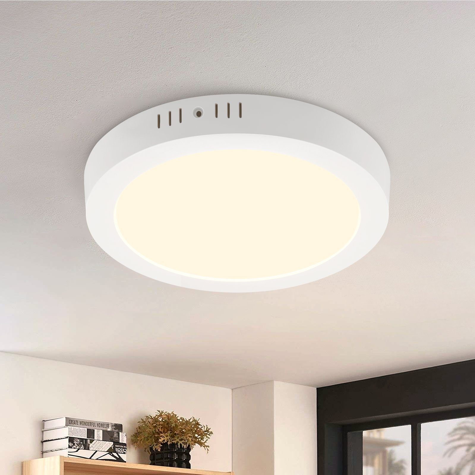 Una plafoniera bianca e rotonda. La luce è accesa e il soffitto è bianco.