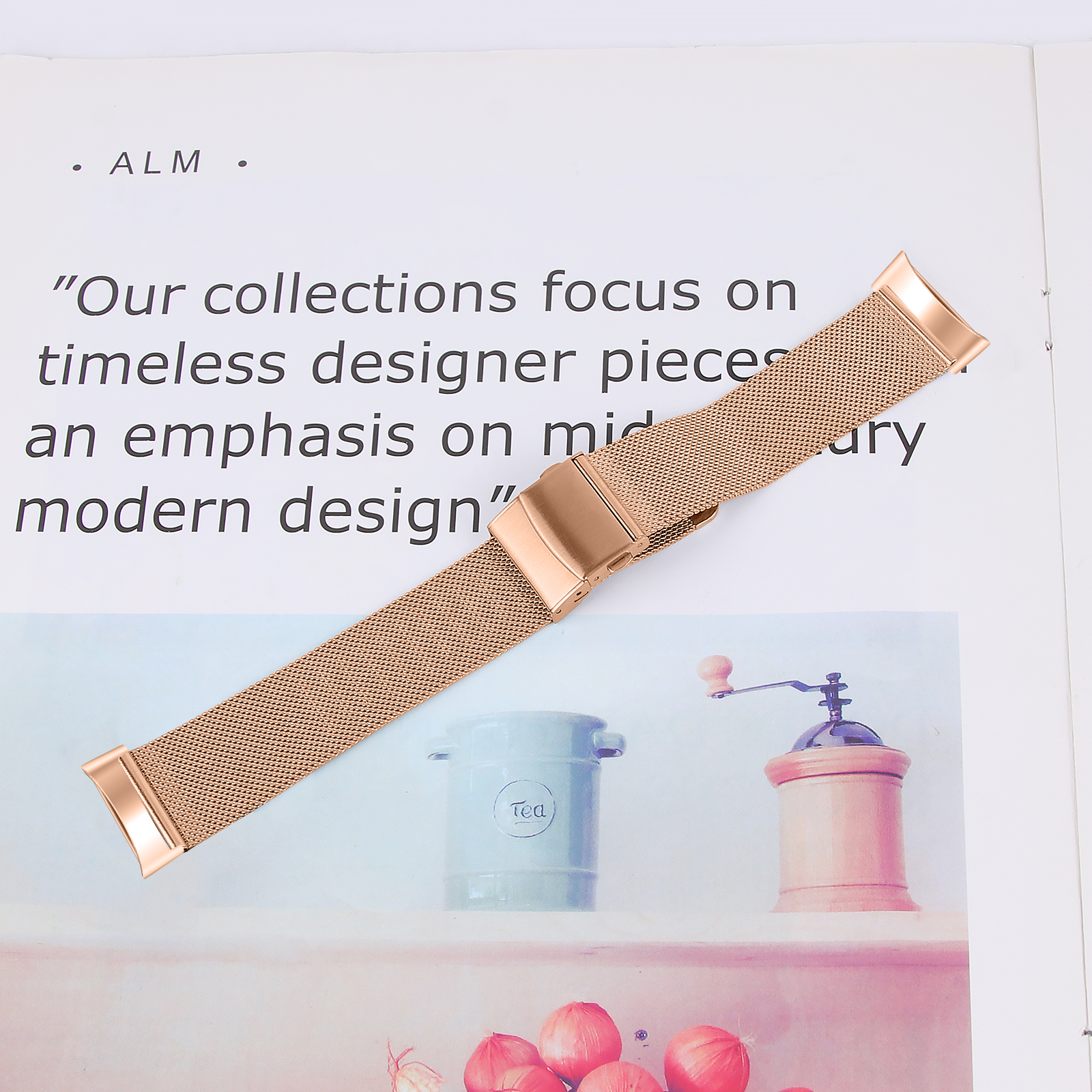 Pasek do zegarka w kolorze różowego złota z siateczkowym wzorem, na białej powierzchni.