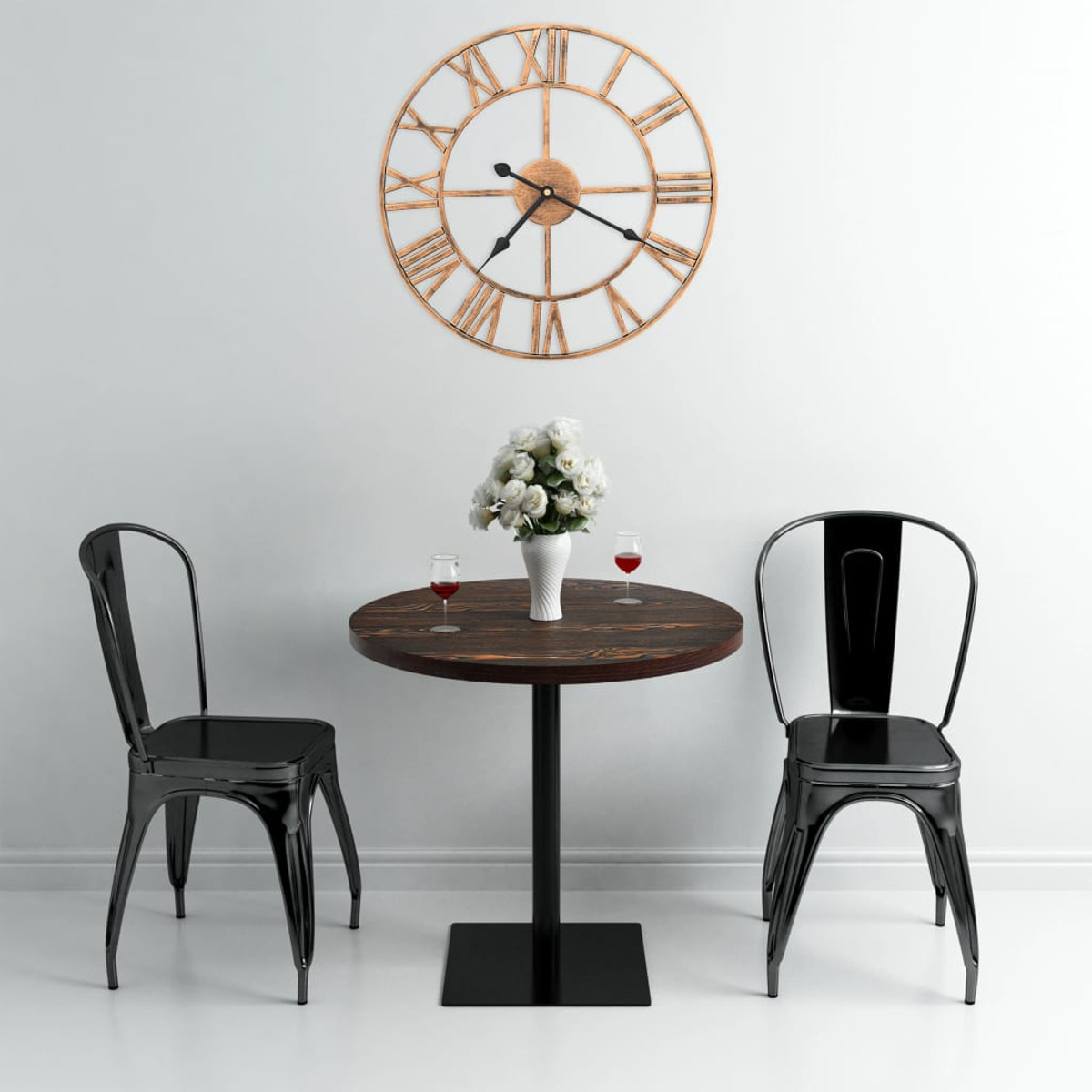 Tavolo rotondo con due sedie e parete bianca. Un orologio sul muro. Vaso con fiori.