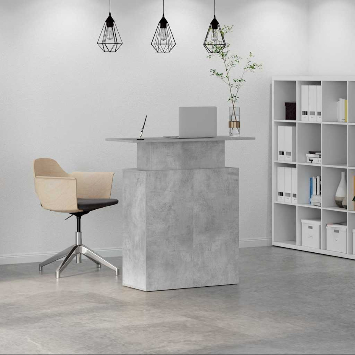 Ein grauer Betontisch mit Laptop, Stuhl und weißem Regal.
