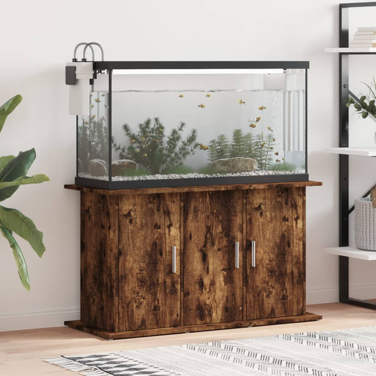 Ein Aquarium auf einem Holzschrank, mit Pflanzen, Fischen und einem Filter.