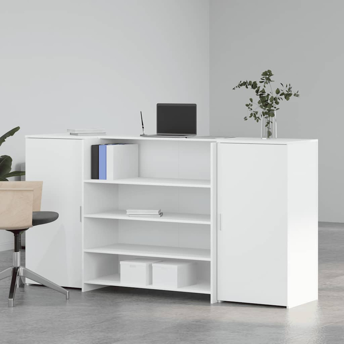Ein weißer Schreibtisch mit Regalen, Laptop, Büchern und Pflanzen vor weißer Wand.