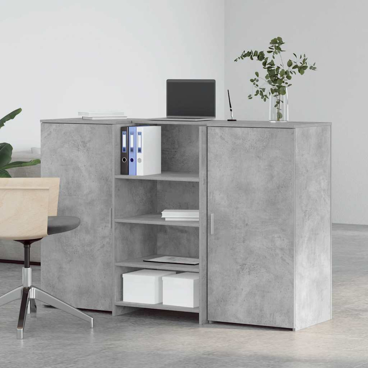 Ein grauer Bürotisch mit Laptop, Akten und Aufbewahrungsboxen. Stuhl und Sofa im Hintergrund.