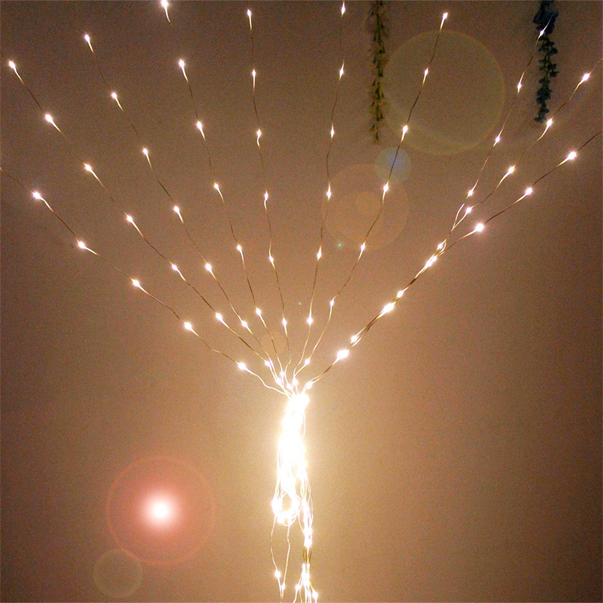 Lichterketten hängen von der Decke, geben warmes Licht ab. Licht strahlt nach unten.