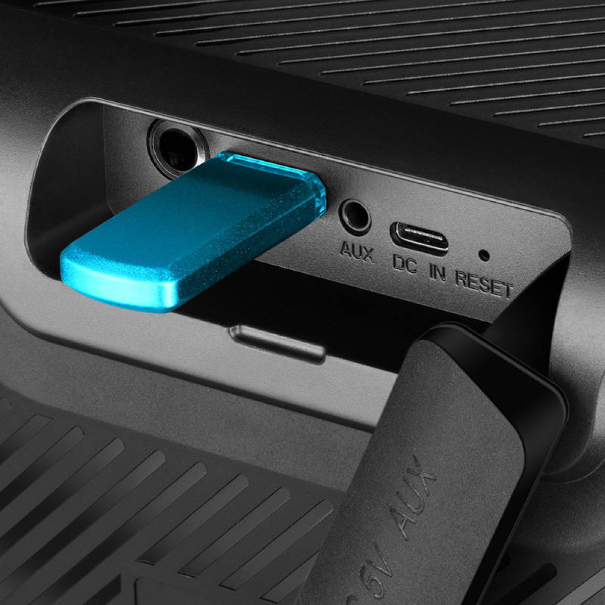 Dispositivo nero con una chiavetta USB blu. Sfondo nero.
