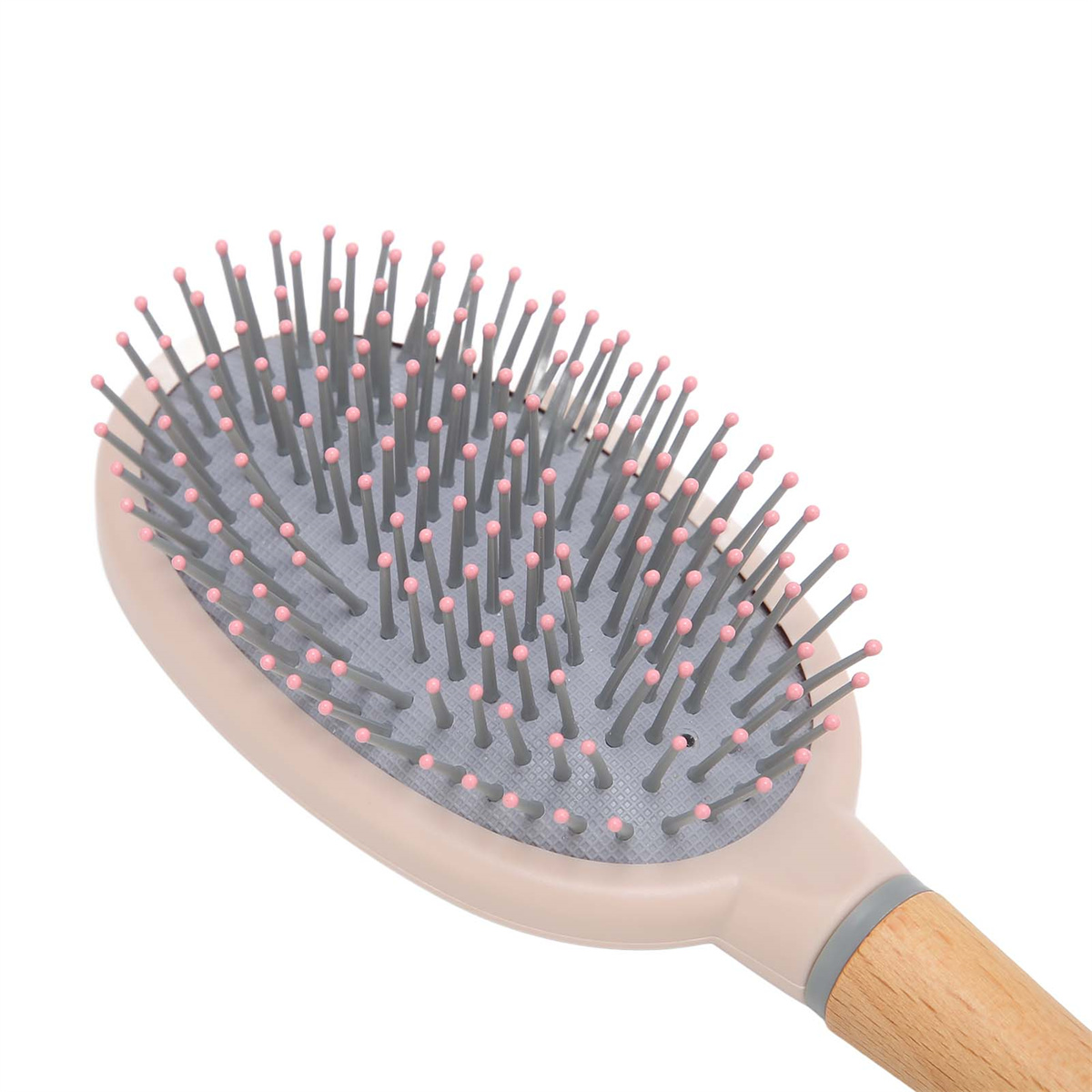 Eine beige Haarbürste mit vielen grauen Borsten und rosa Spitzen. Holzgriff. Weißer Hintergrund.