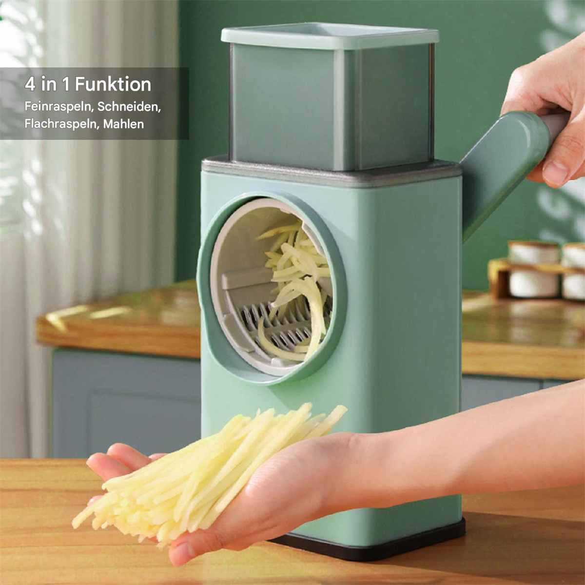 Gemüseschneider, mit einer Hand, die geschnittene Kartoffeln hält. Maschine ist grün, mit weißem Hintergrund.