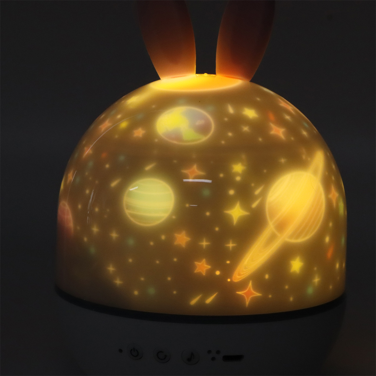 Ein Nachtlicht in Form einer Kuppel, das Sterne und Planeten projiziert. Es hat Hasenohren.