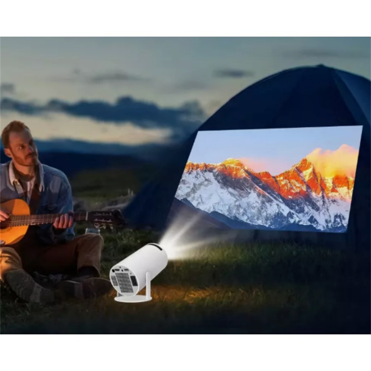 Mann spielt Gitarre, projiziertes Bild eines Bergpanoramas auf einem Zelt.