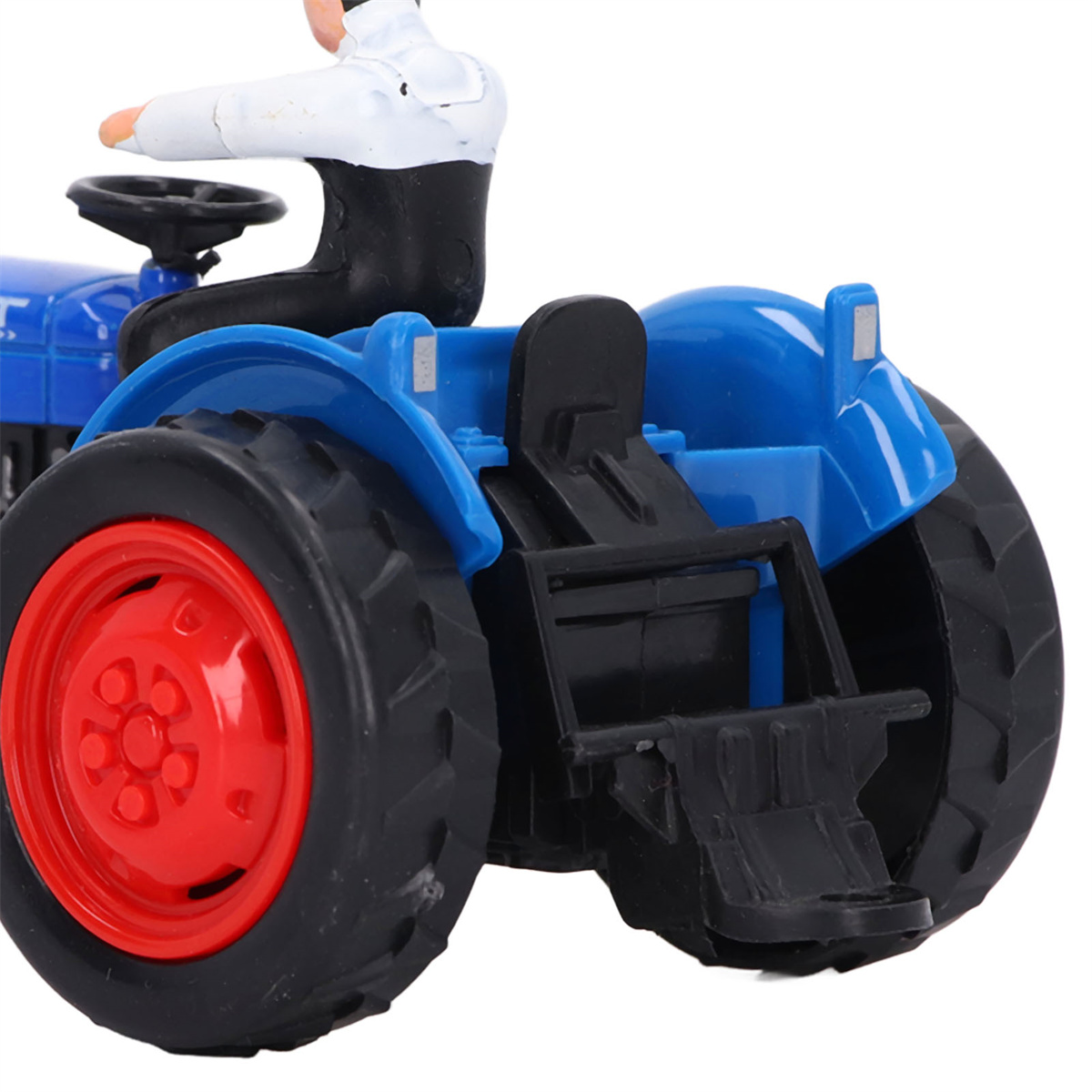 Ein blauer Spielzeugtraktor mit roten Rädern und einer kleinen Figur einer Person, die ihn fährt.
