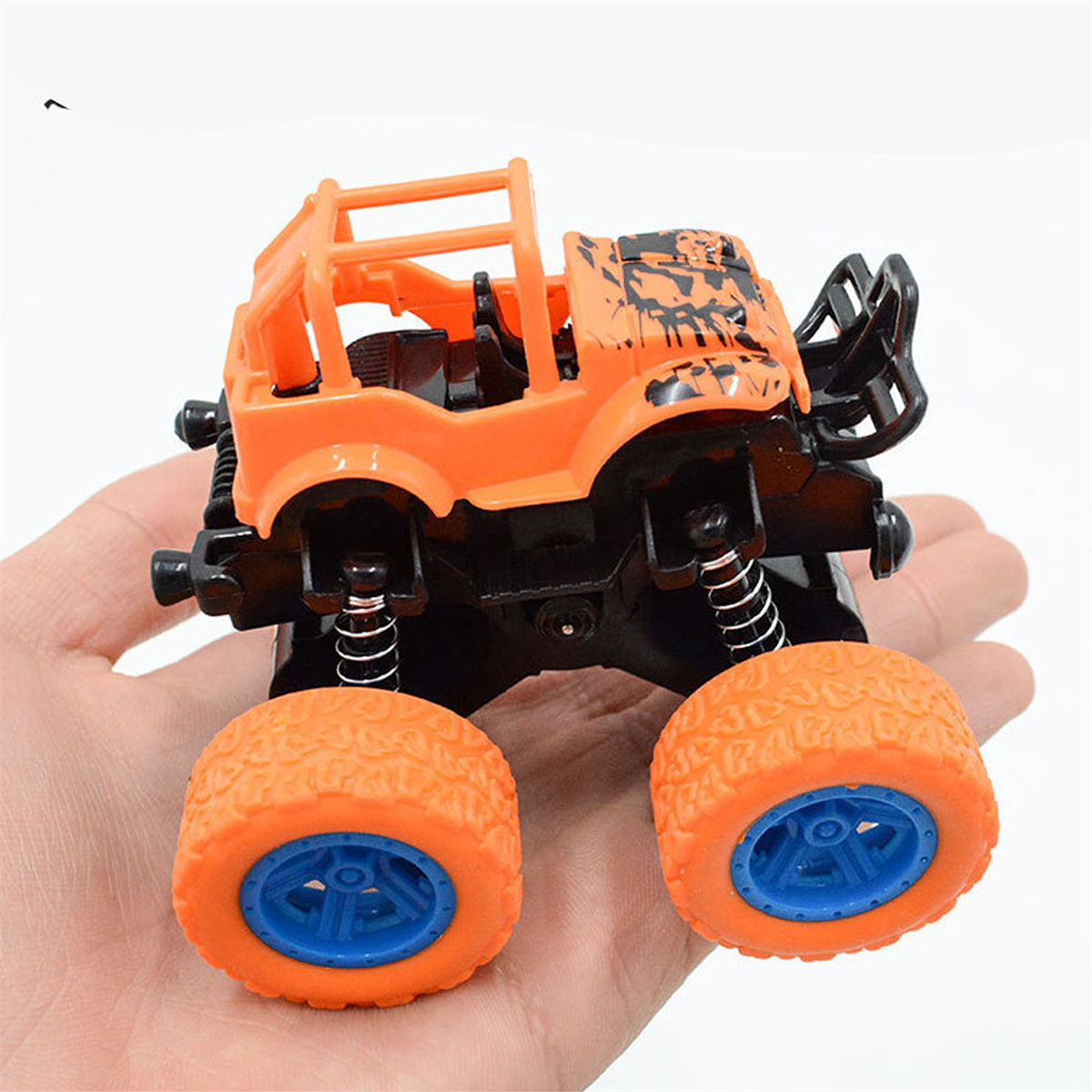 Ein orangefarbenes und schwarzes Monstertruck-Spielzeug mit großen Rädern und weißem Hintergrund.