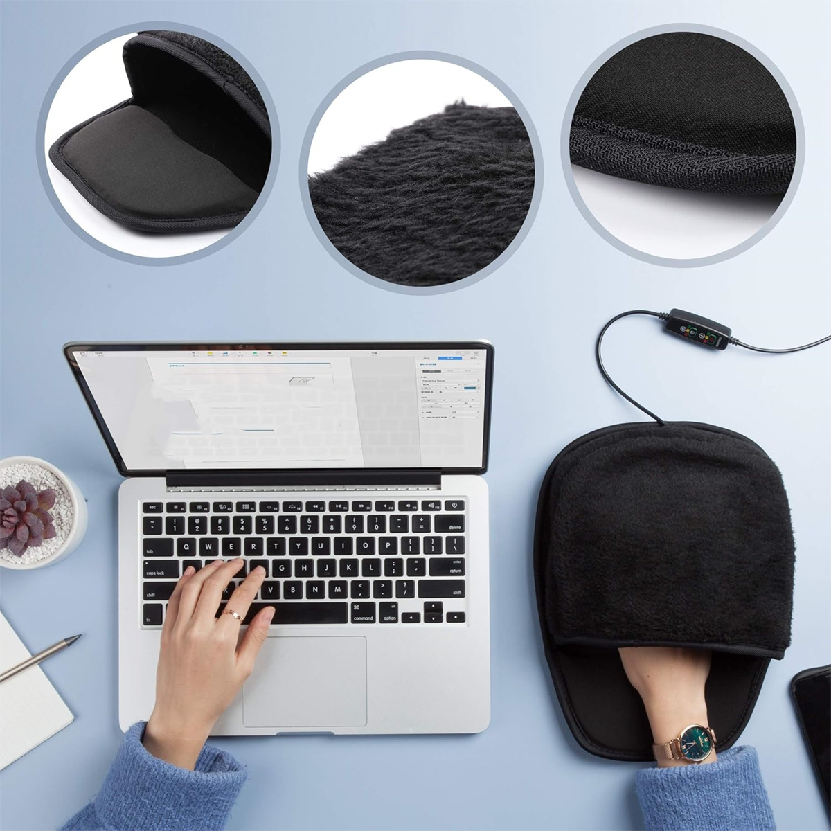 Eine Hand in einem schwarzen Handwärmer mit einem Laptop und einer Tastatur im Hintergrund.