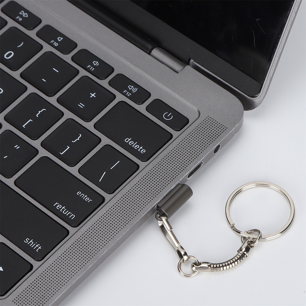 Ein Laptop mit einem Schlüsselanhänger, der an einen USB-C-Anschluss angeschlossen ist.
