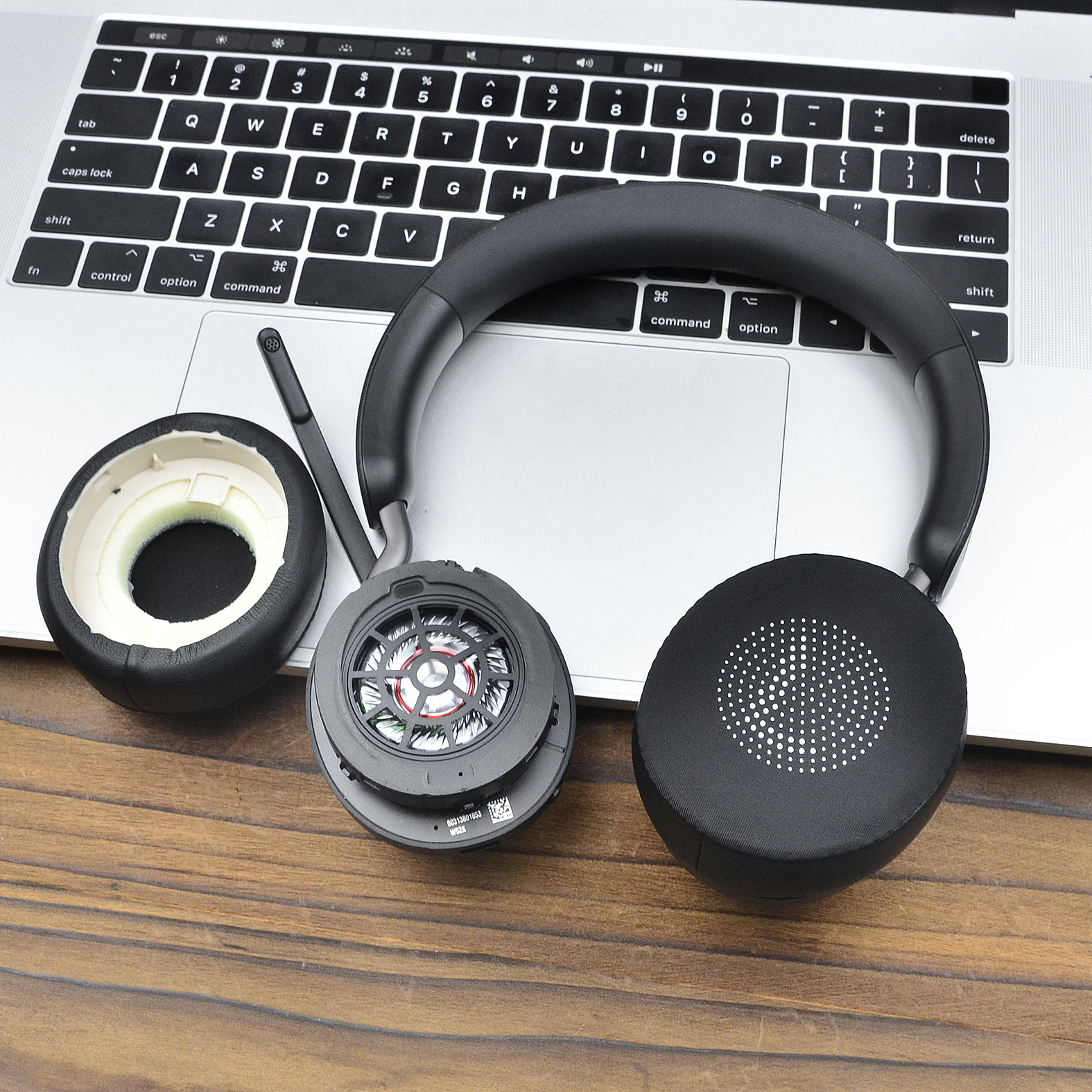 Czarne słuchawki zdemontowane na laptopie. Widoczne nauszniki i elementy wewnętrzne.