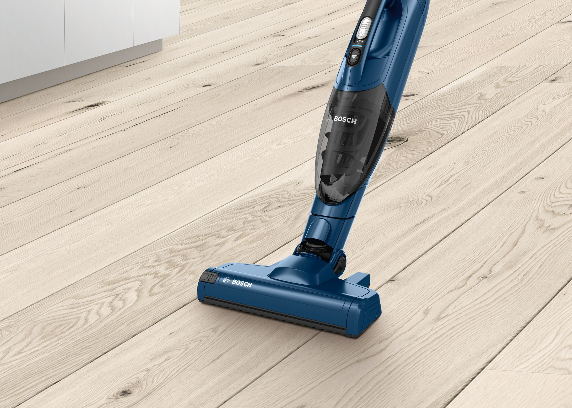 Ein blauer kabelloser Staubsauger reinigt einen hellen Holzboden. Der Staubsauger ist nach unten geneigt.