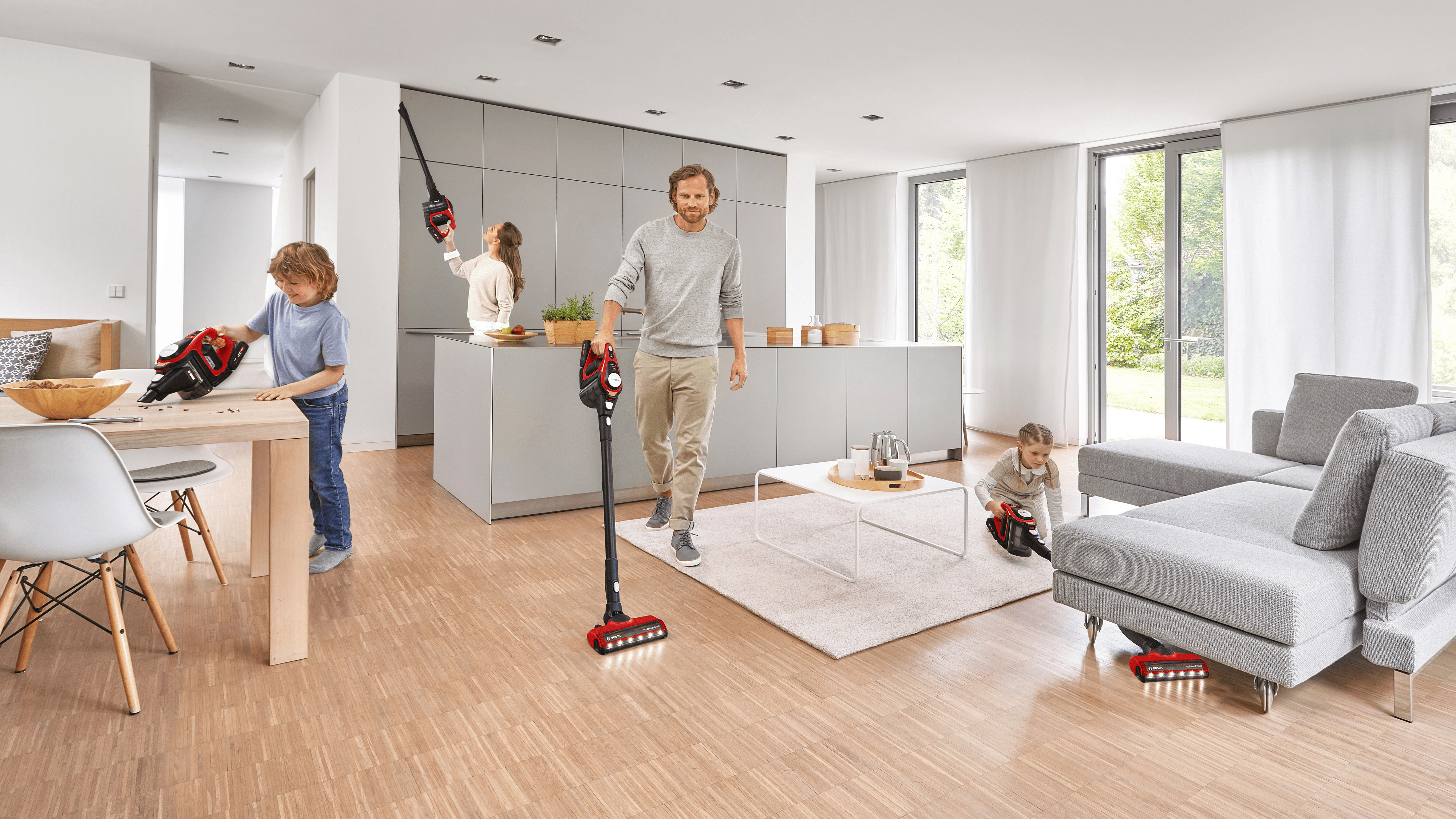 Familie, die ein Haus staubsaugt. Ein Mann und zwei Kinder putzen. Küche und Wohnzimmer sind sichtbar.