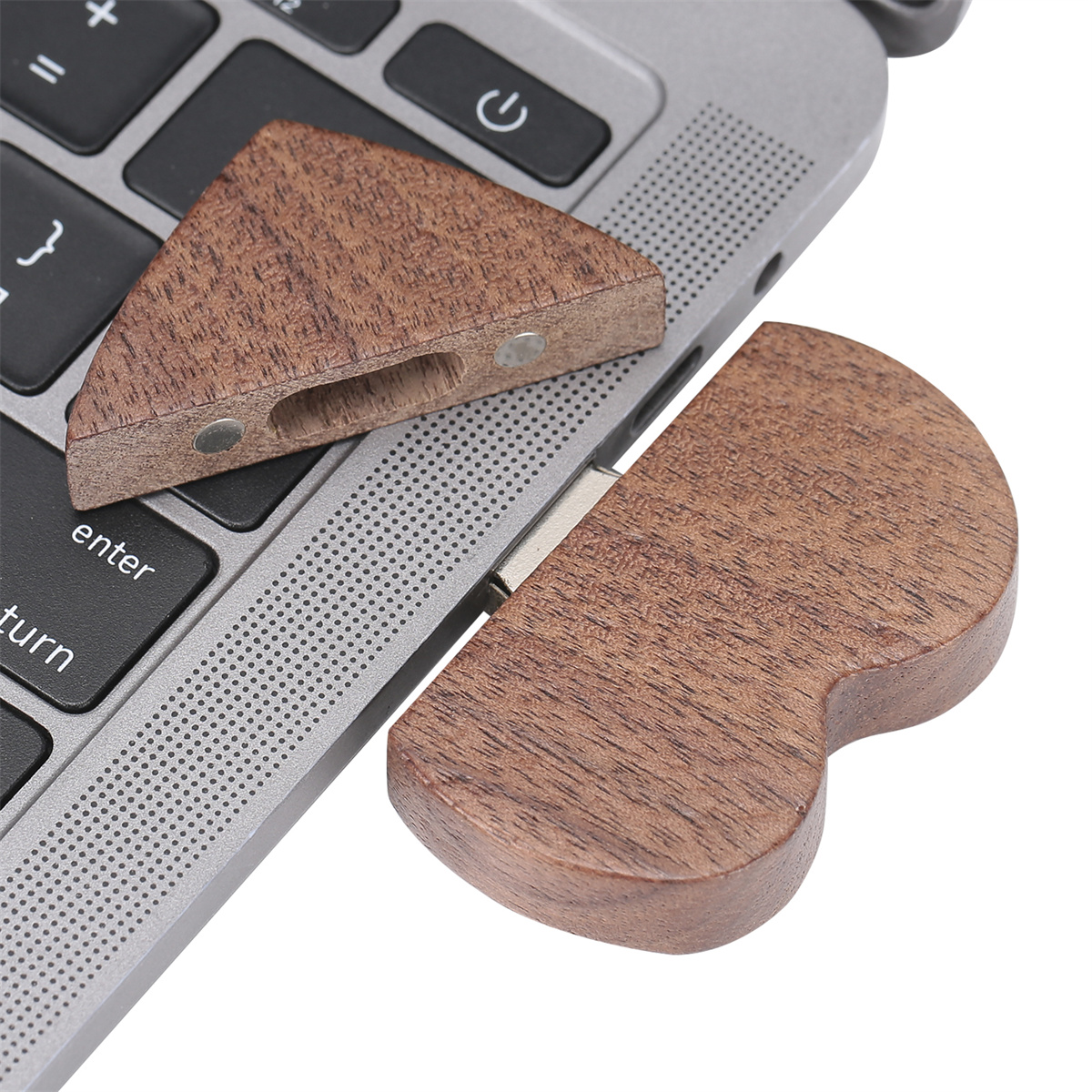 Laptop-Zubehör aus Holz. Zwei Teile neben einer Laptop-Tastatur. Braune Holzmaserung sichtbar.