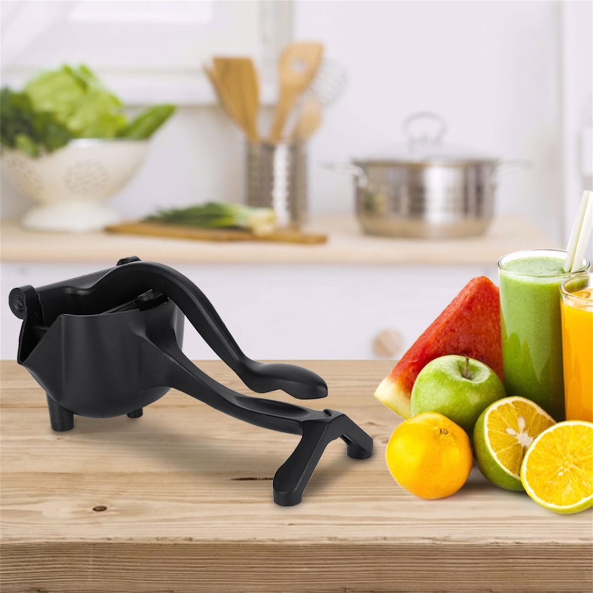 Schwarze Saftpresse mit Holztisch, umgeben von Obst und Gläsern Saft.