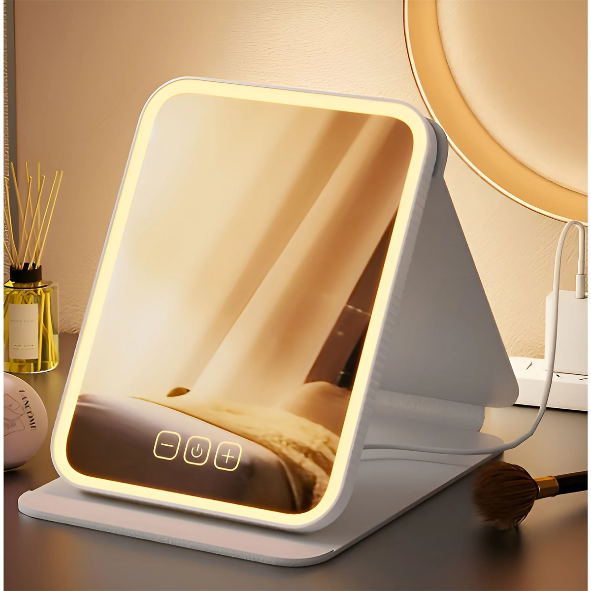 Ein weißer beleuchteter Schminkspiegel auf einem Tisch. Er hat Touch-Bedienelemente und warmes Licht.
