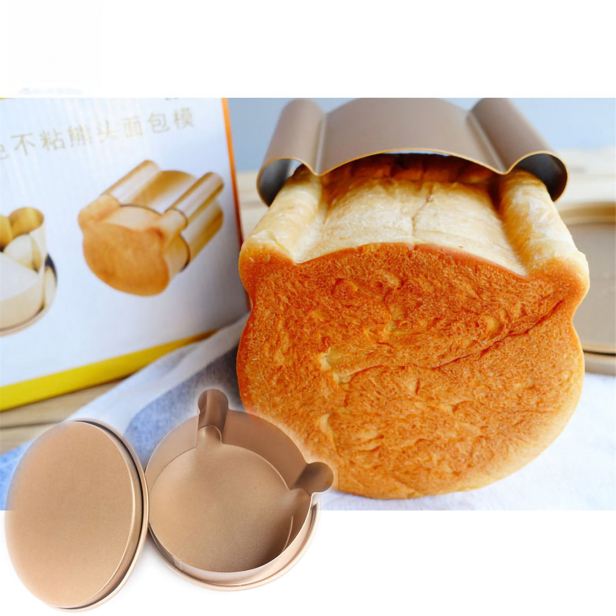 Brotlaib in einer Brotform, mit runden Brotformen und einer Schachtel. Das Brot ist goldbraun.