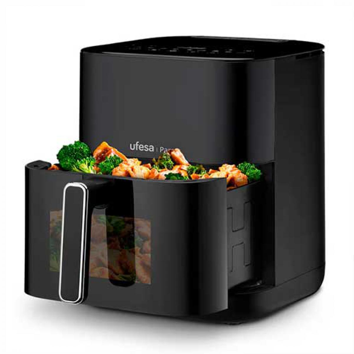 Czarna frytkownica powietrzna z jedzeniem w środku i uchwytem.