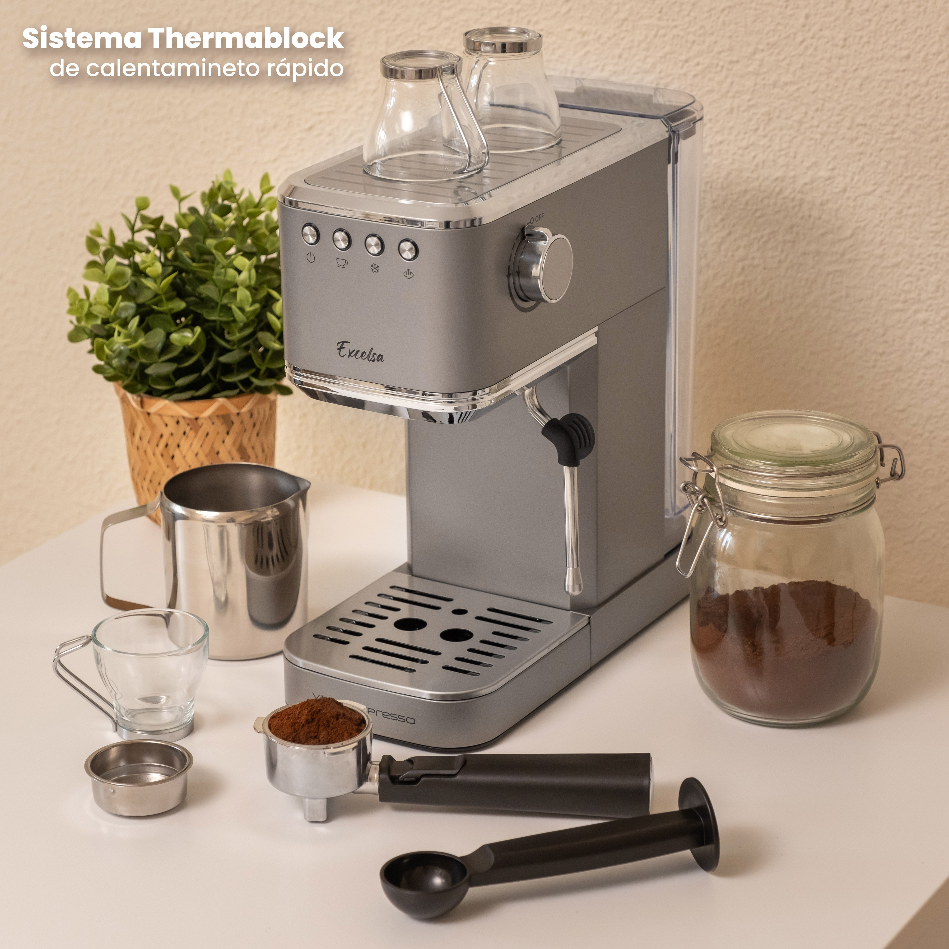 Máquina de espresso gris con accesorios de café. Incluye café, tazas y un frasco.