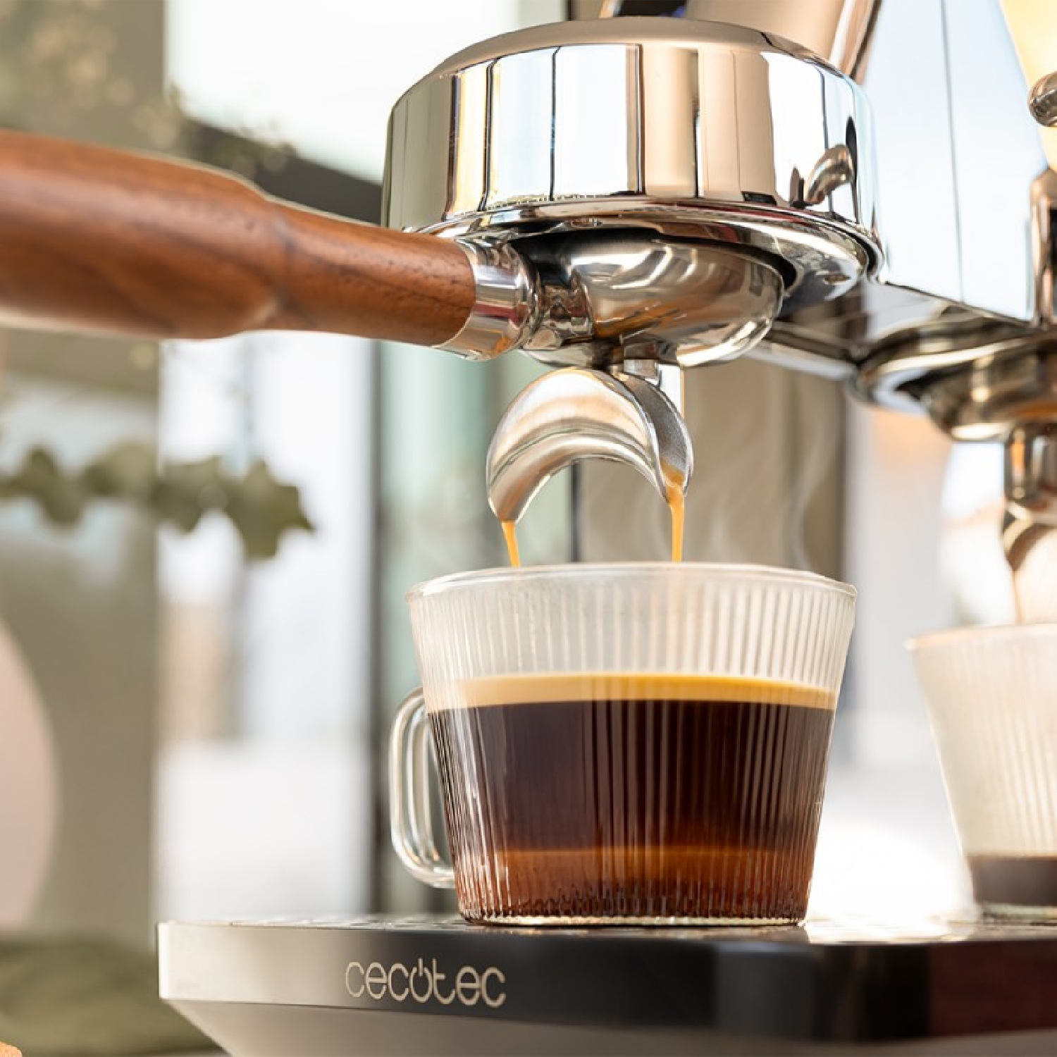 Ekspres do kawy nalewający kawę do szklanki. Na pierwszym planie: ekspres, kawa, filiżanka.