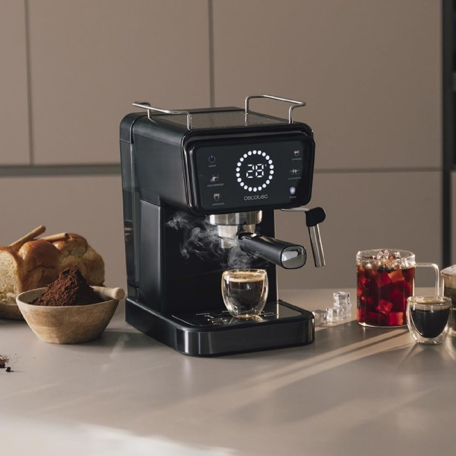 Schwarze Espressomaschine mit einem kleinen Glas Kaffee. Verschiedene Artikel stehen auf einem Tisch.