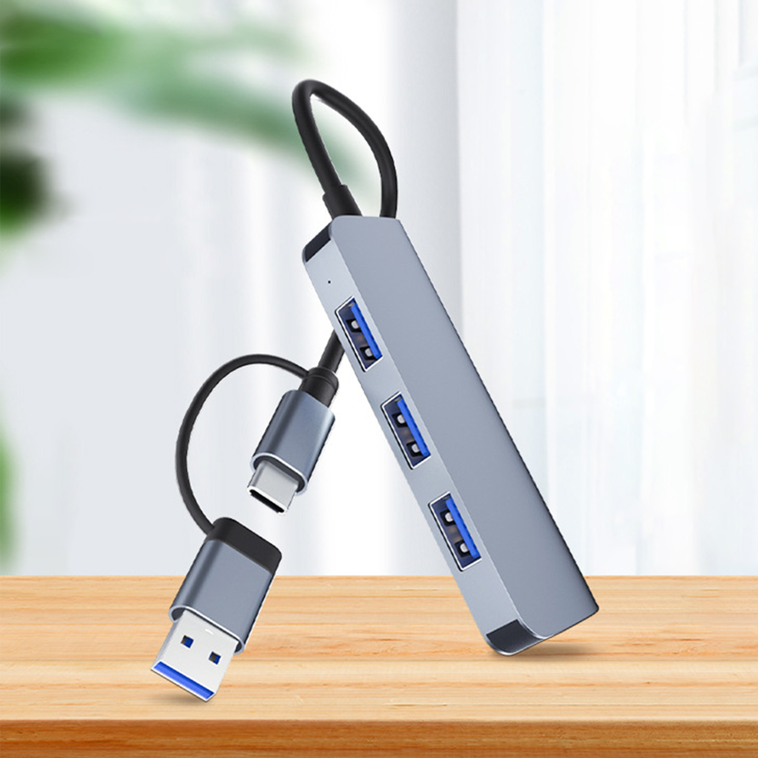 Ein silberner USB-Hub mit drei USB-Anschlüssen, einem USB-C-Anschluss und einem USB-Anschluss.