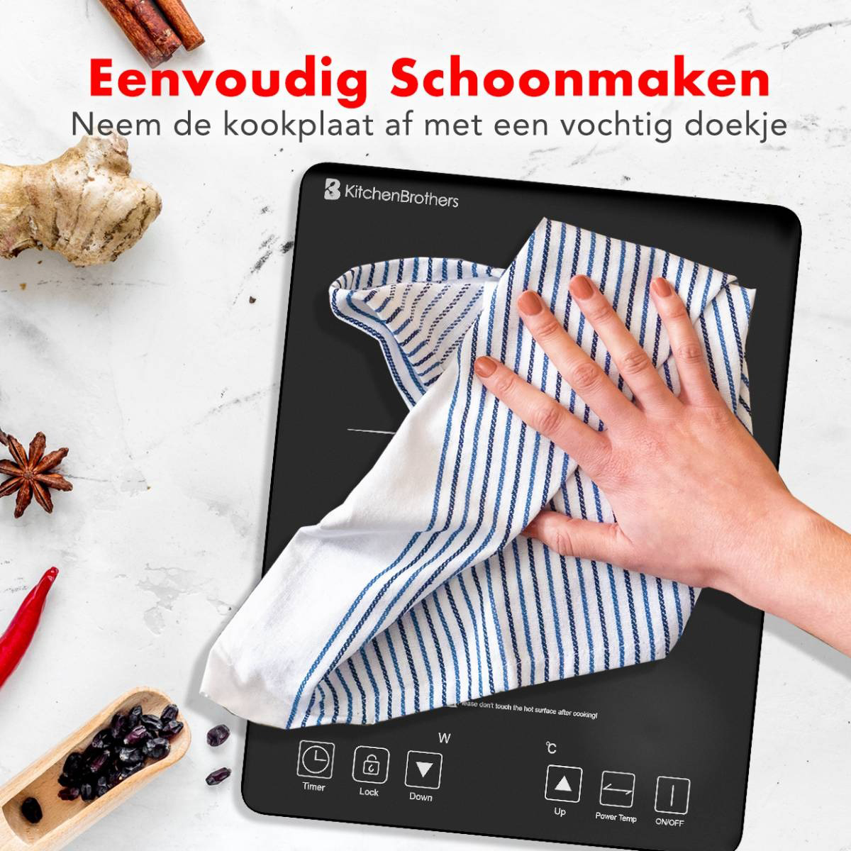 Een zwarte inductiekookplaat die wordt schoongeveegd met een gestreepte doek, plus ingrediënten zoals gember en chili.