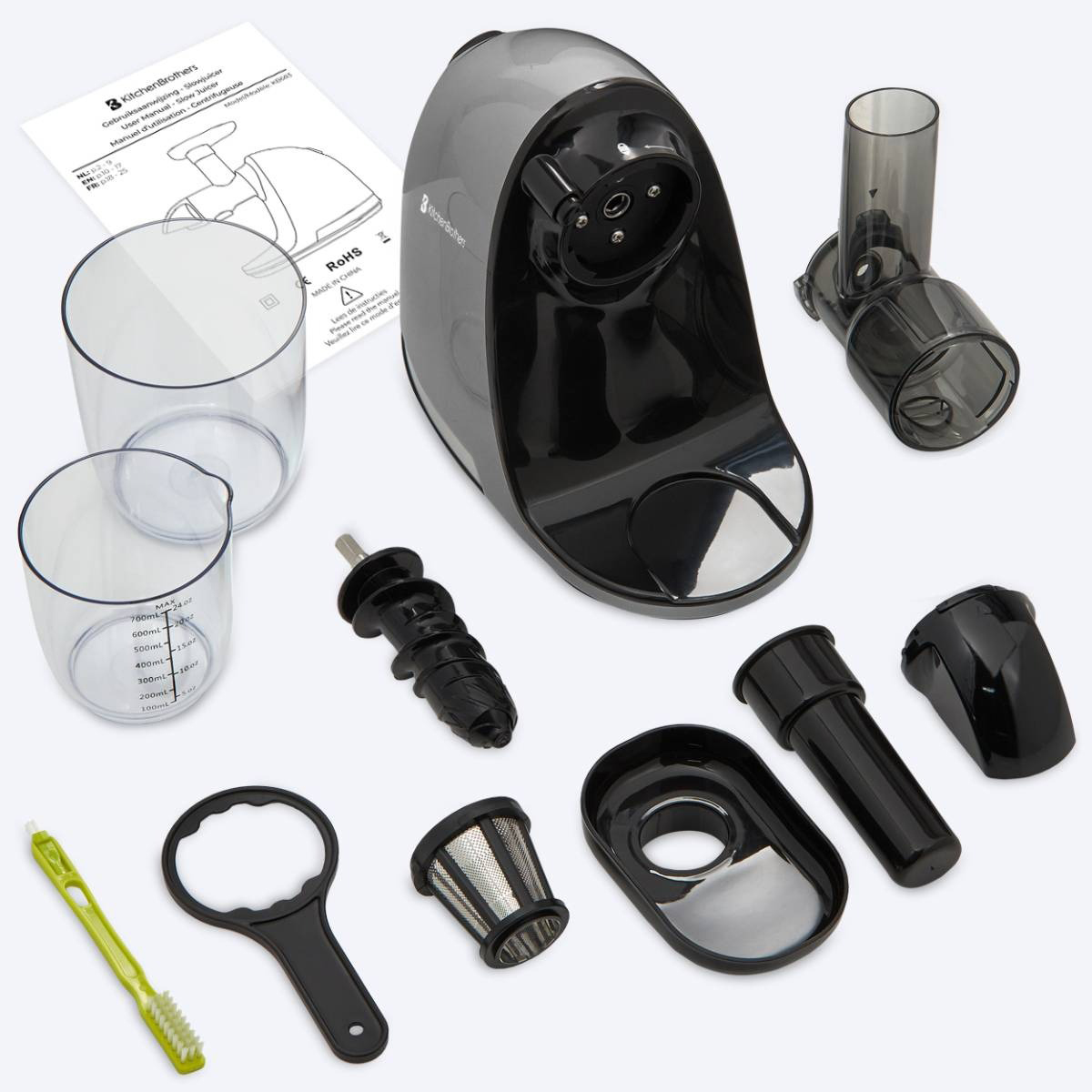 Various parts of a juicer are laid out. Includes the main body, cups, and other components.