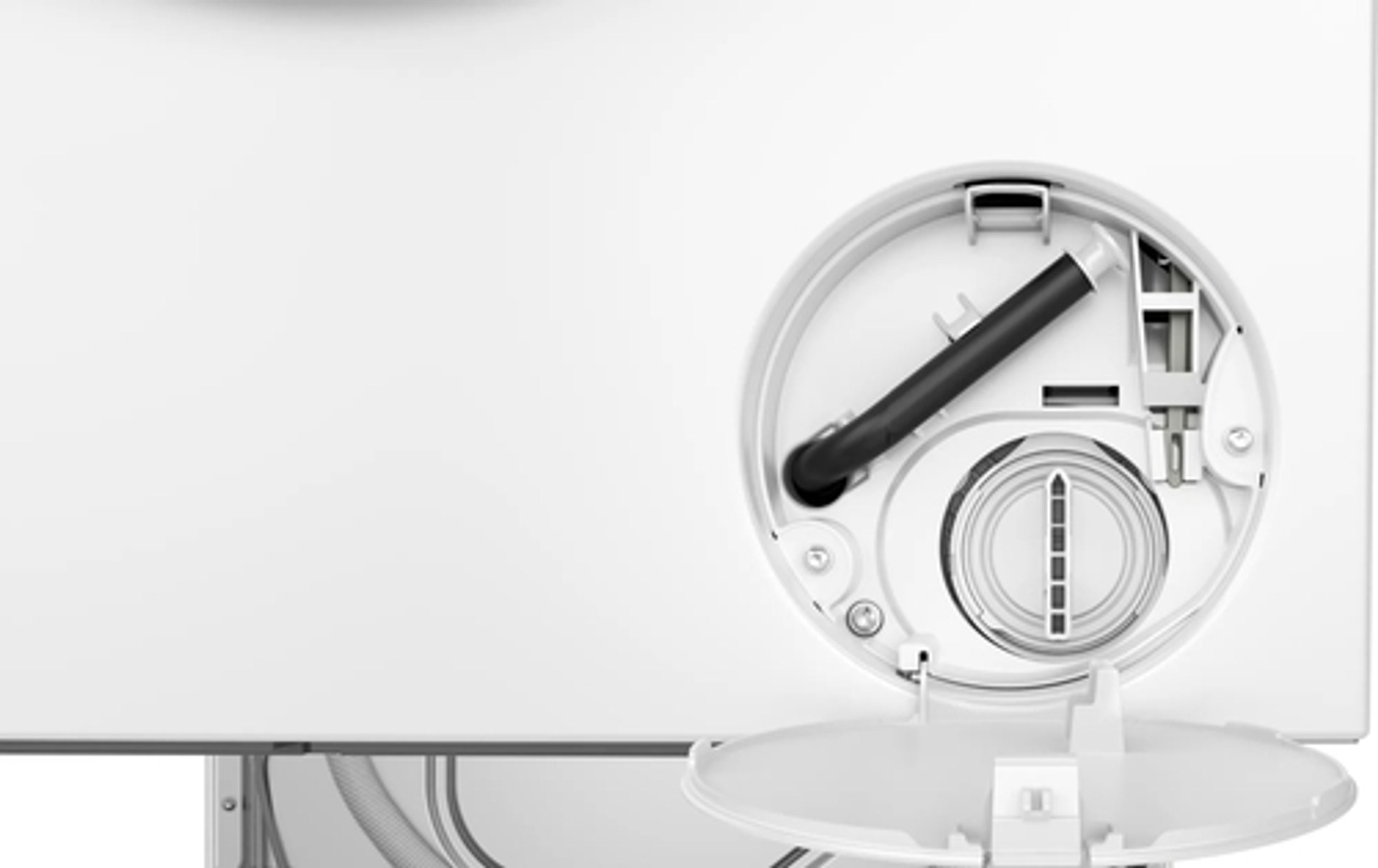 Zbliżenie białej części urządzenia z okrągłym otworem, czarnym wężem i małymi drzwiami.