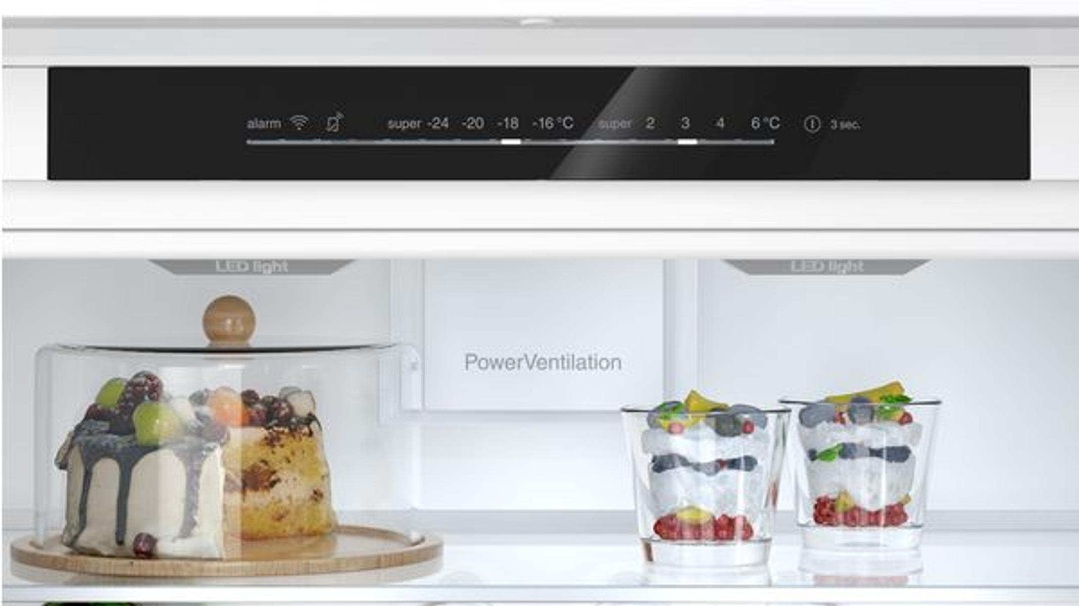 Koelkastinterieur met planken, voedsel en digitaal temperatuurdisplay.