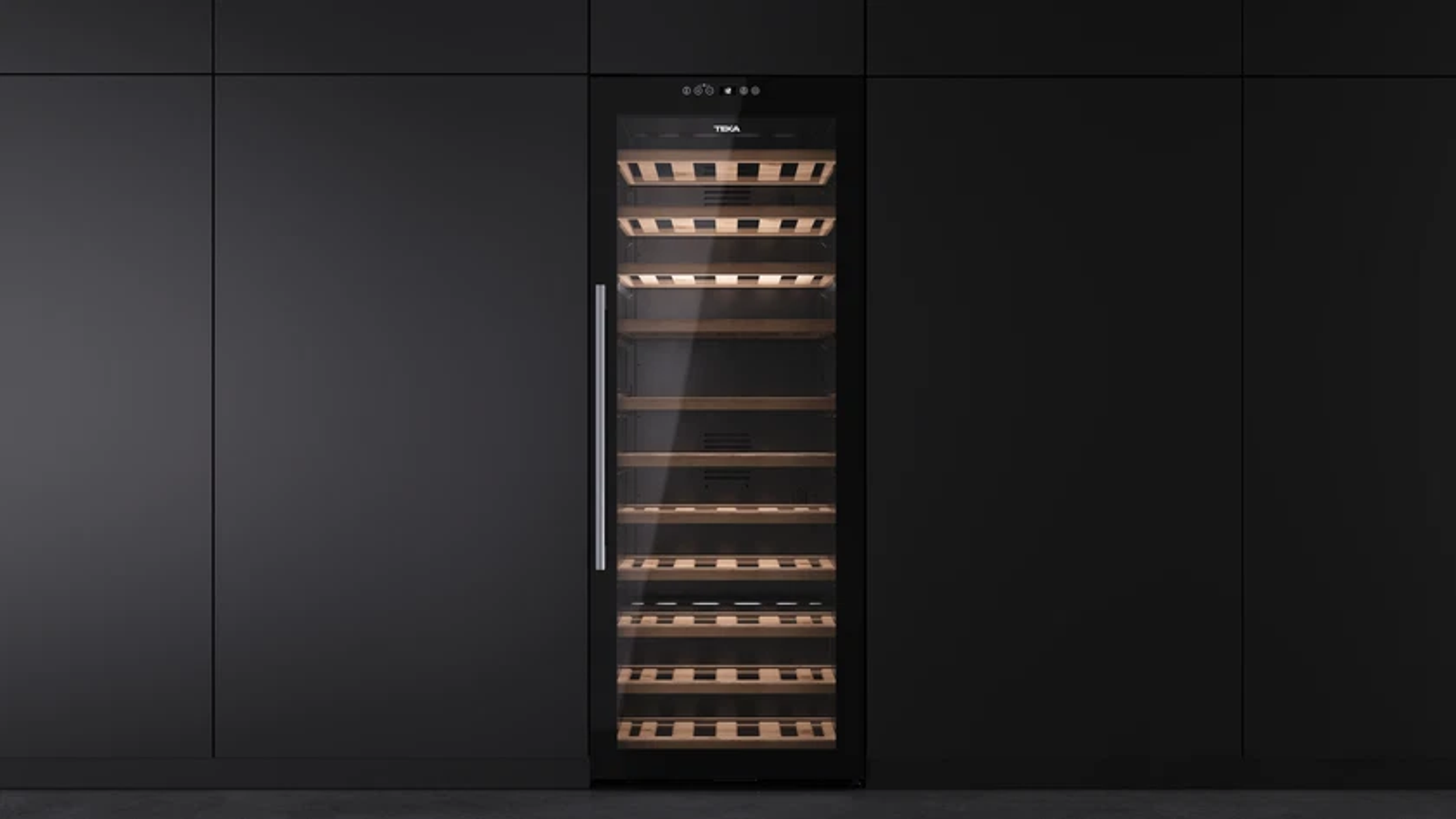 Chłodziarka do wina wbudowana w ścianę, ze szklanymi drzwiami odsłaniającymi drewniane półki i butelki wina.