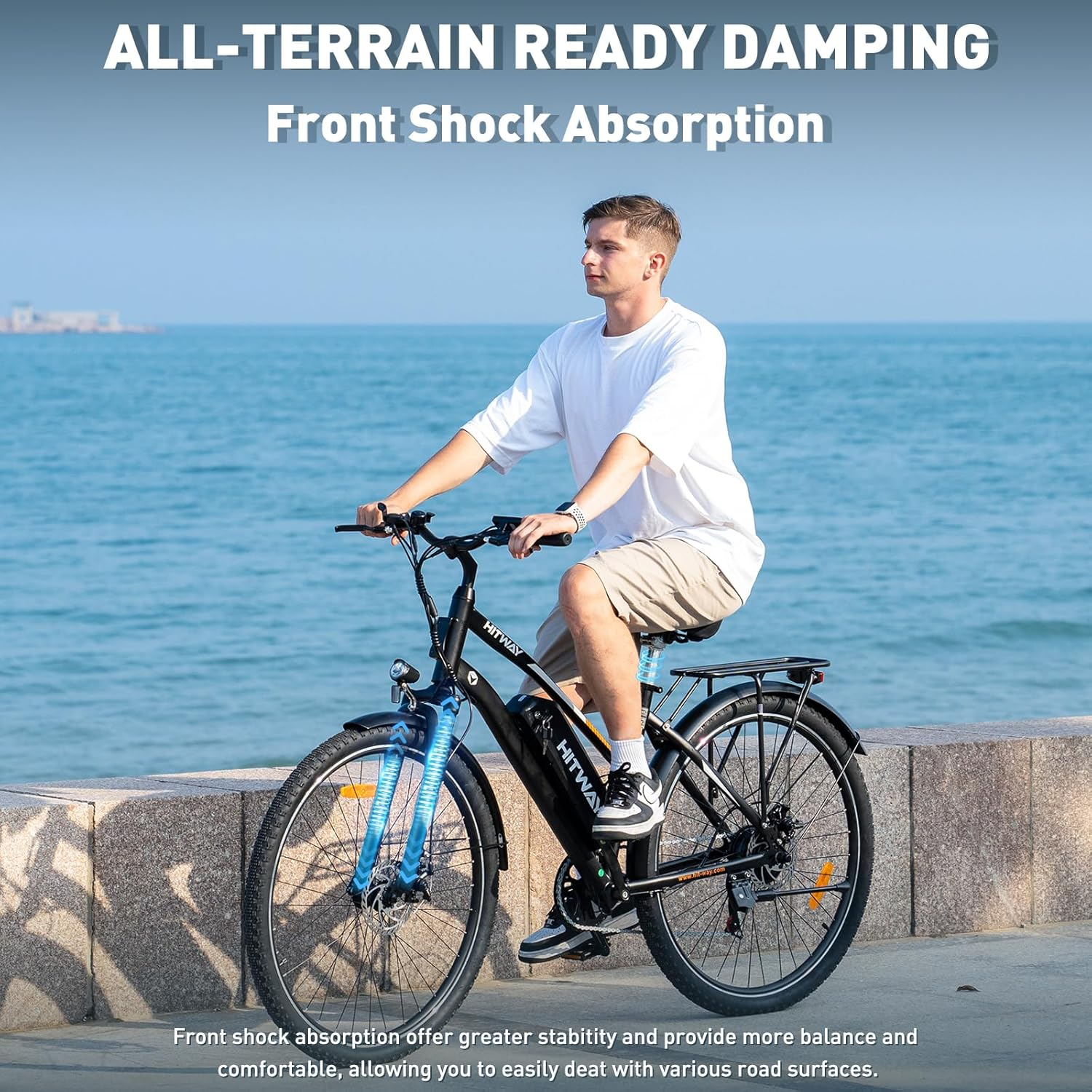 Mężczyzna jadący czarno-niebieskim rowerem elektrycznym na wybrzeżu.